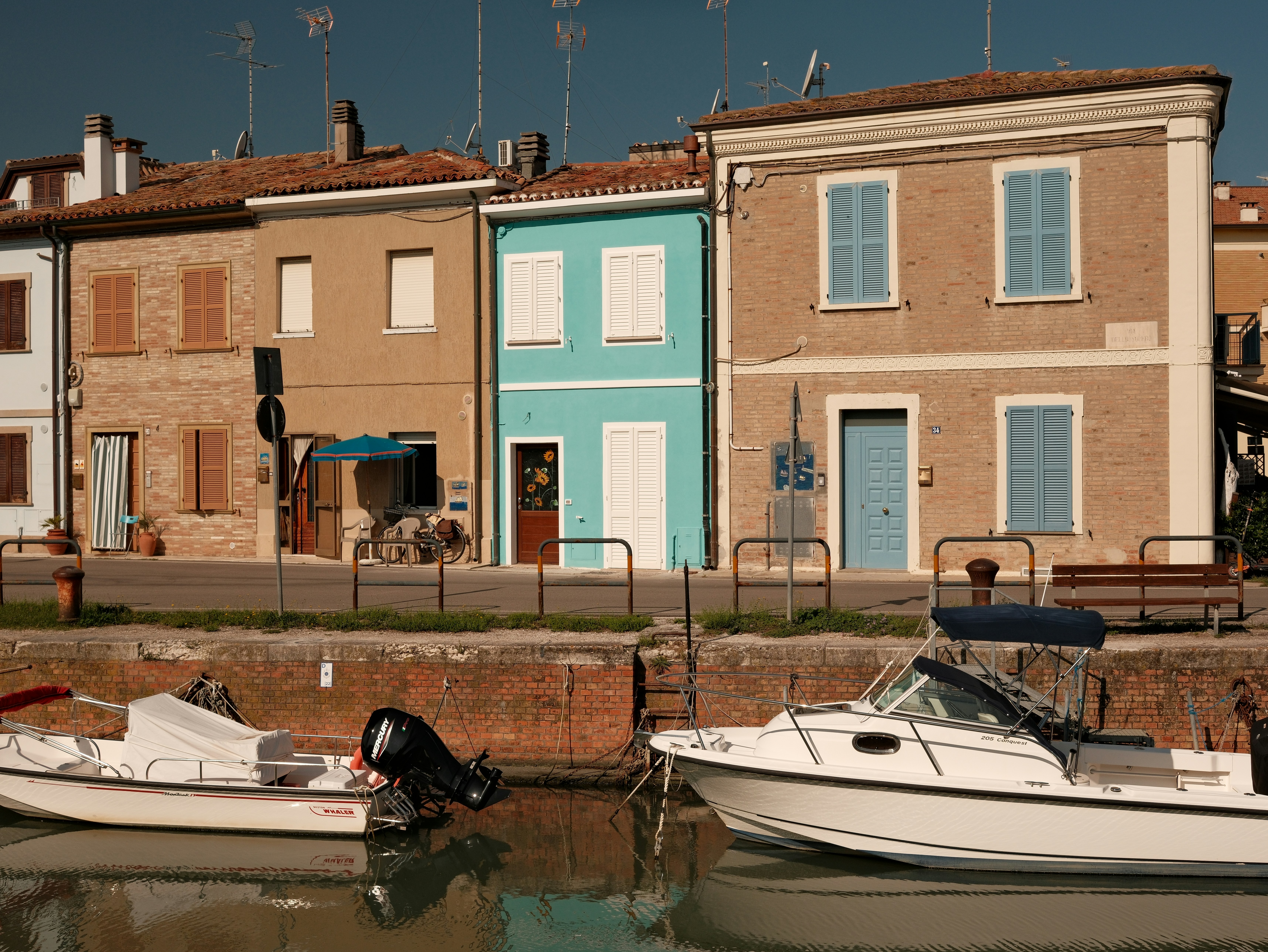 Barche ormeggiate da edifici colorati lungo un canale.