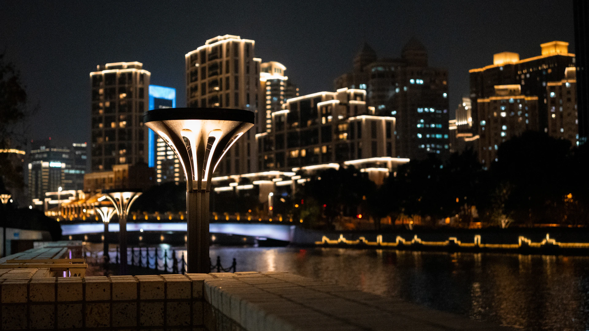 City skyline illuminated at night with a river.