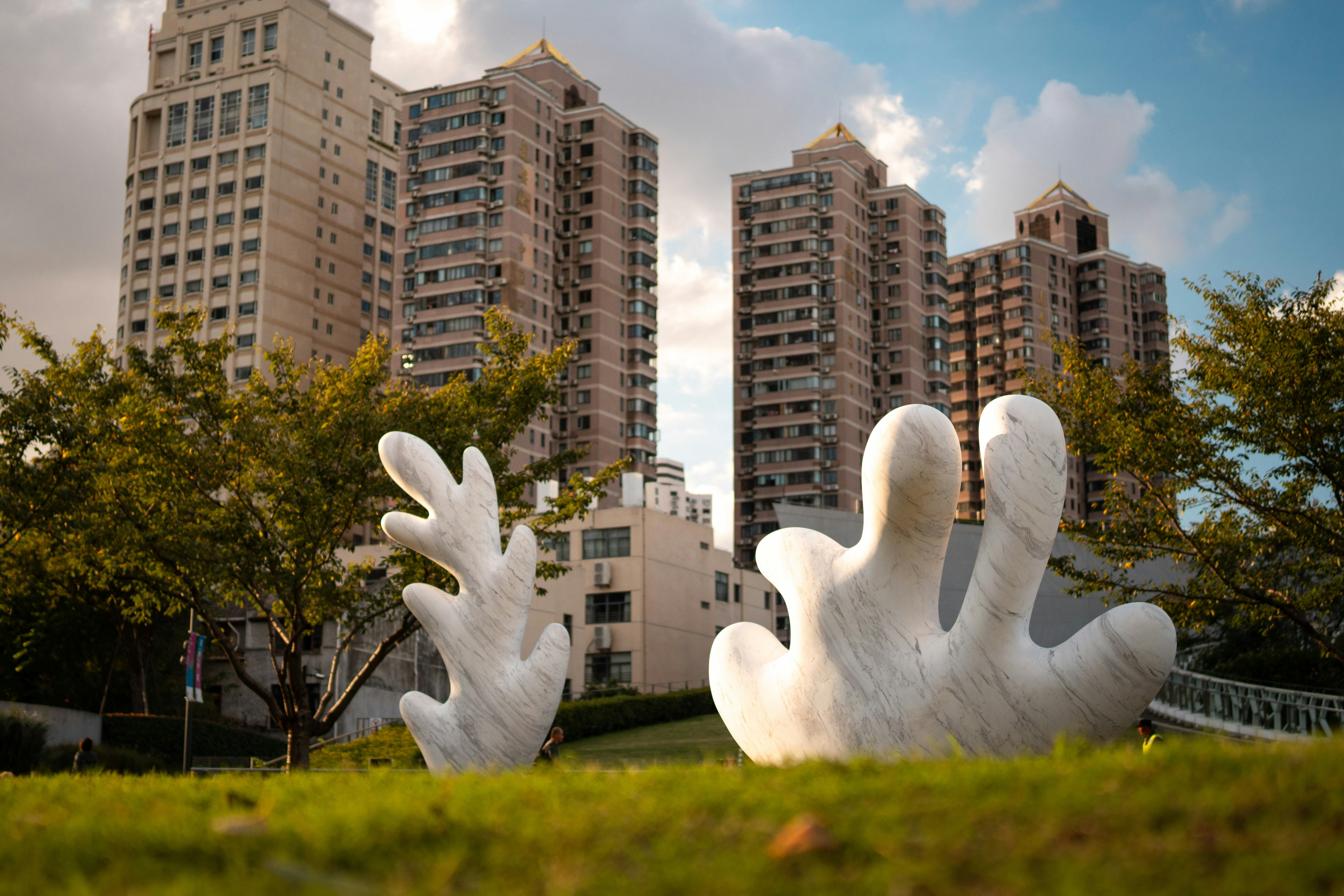 Sculptures in a park with buildings behind