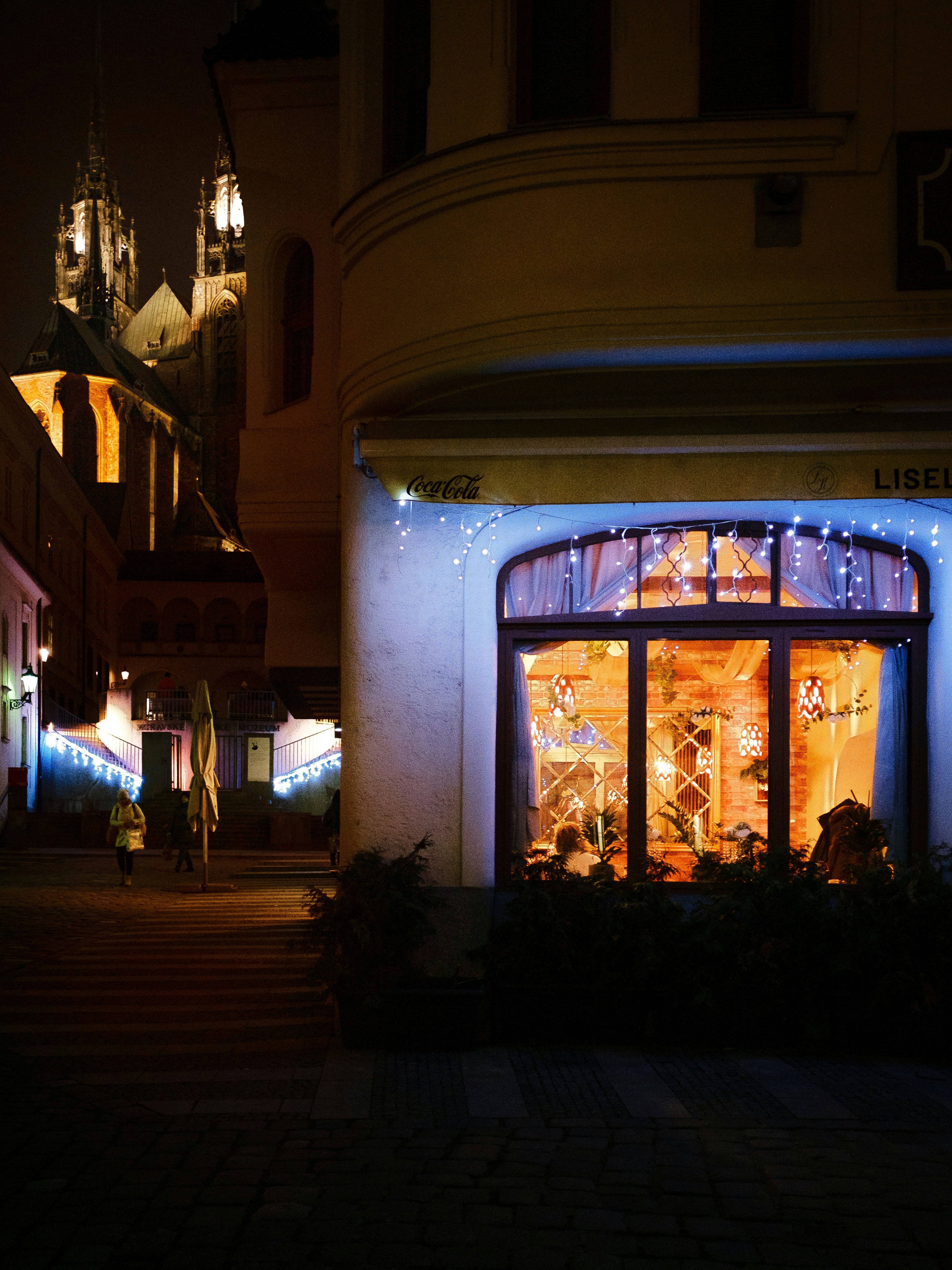 A street scene at night with illuminated buildings.