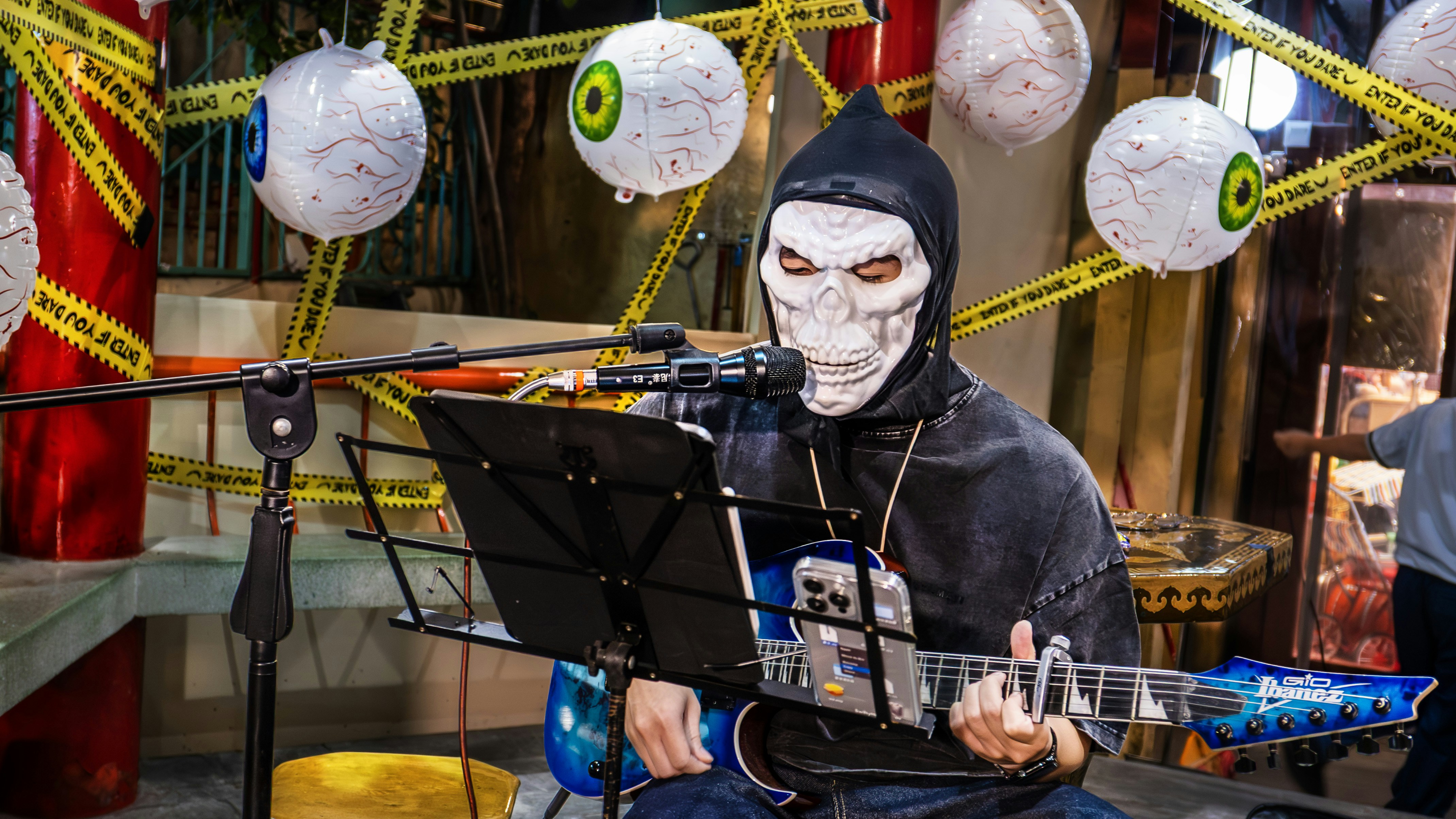 Person im Sensenmann-Kostüm spielt Gitarre