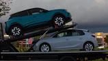 Two cars loaded onto a car carrier truck.
