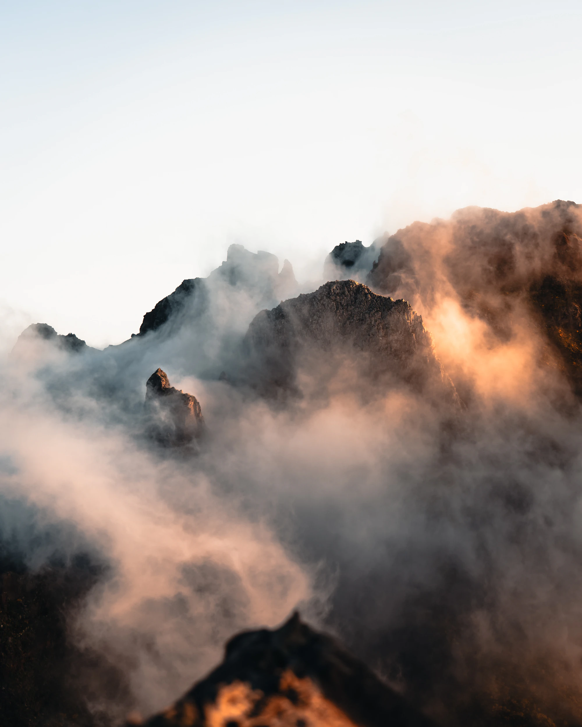 Montañas entre la niebla al amanecer, con luz cálida