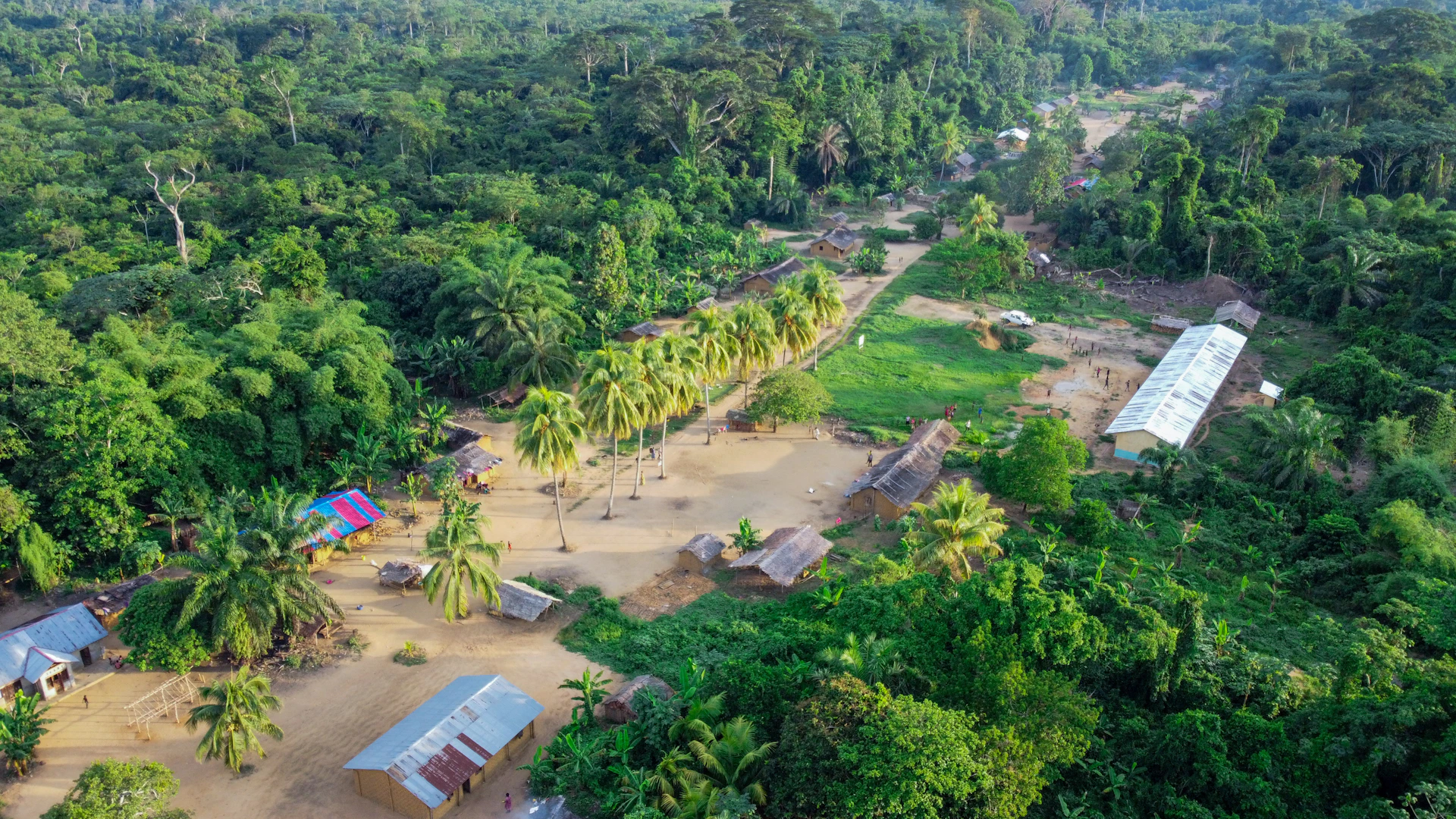 Aerial view of a flooded village surrounded by lush jungle.