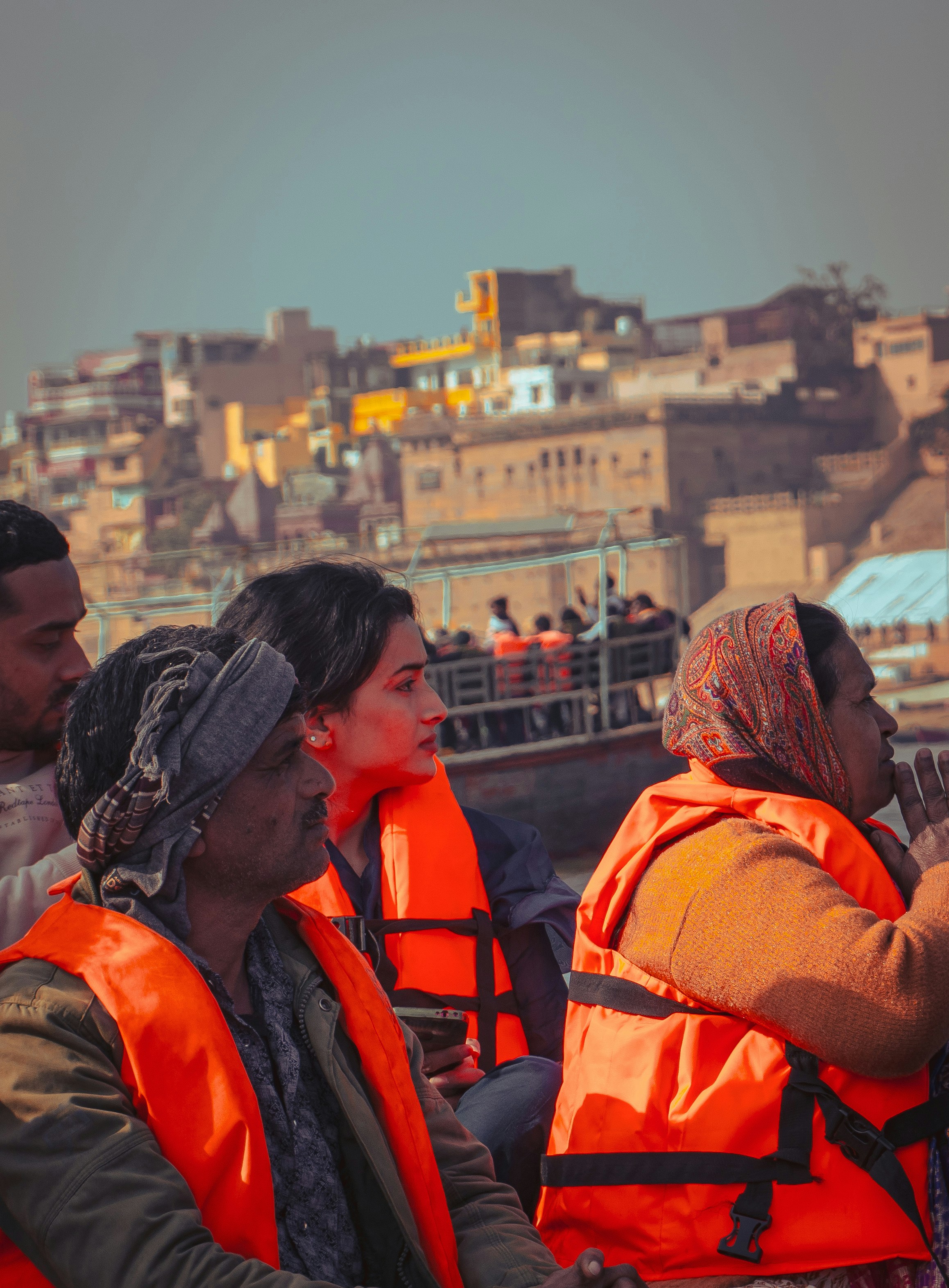 Menschen mit orangefarbenen Schwimmwesten auf einem Boot