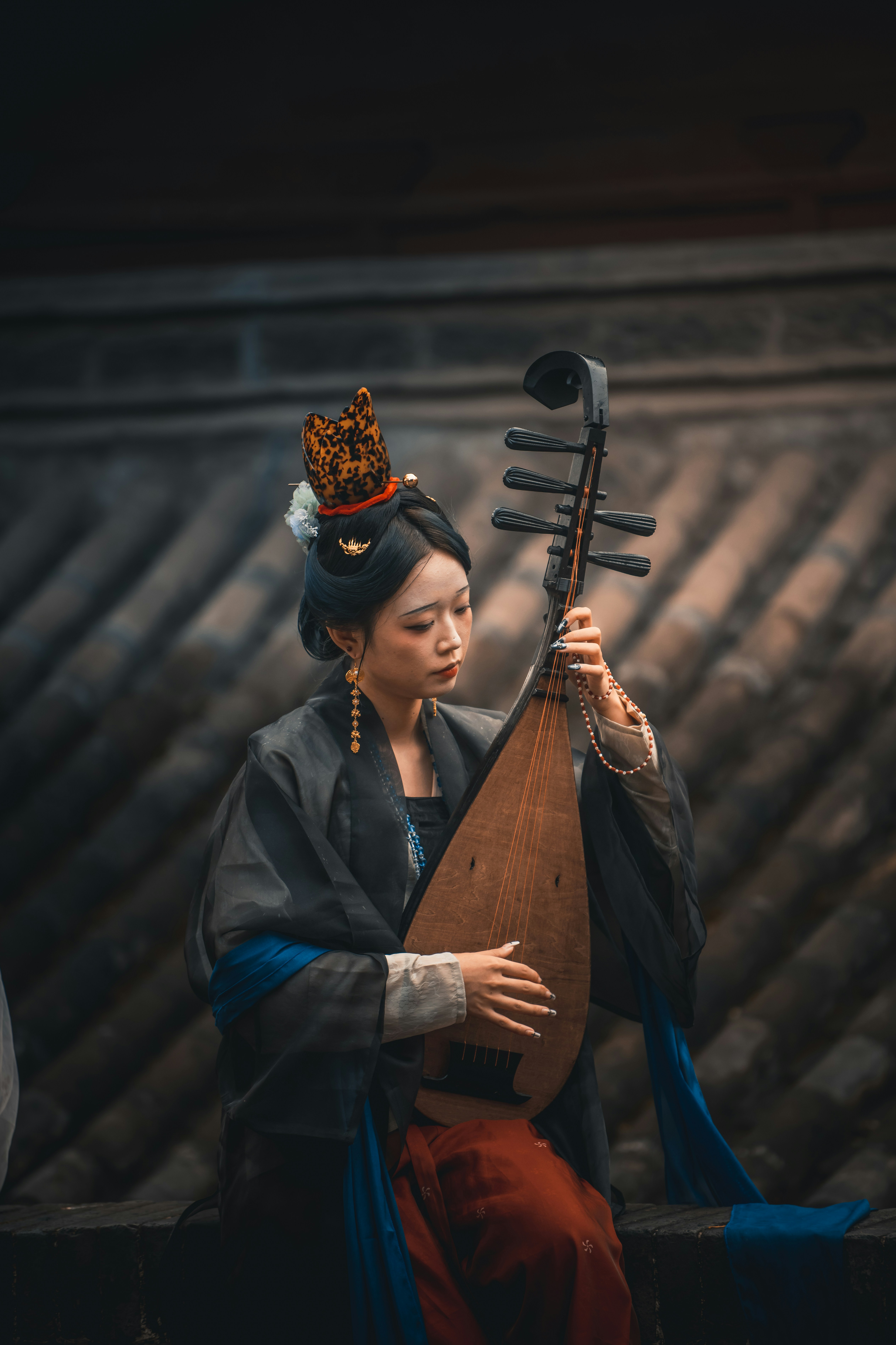 Woman in traditional chinese attire playing pipa