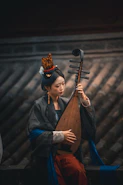 Woman in traditional chinese attire playing pipa