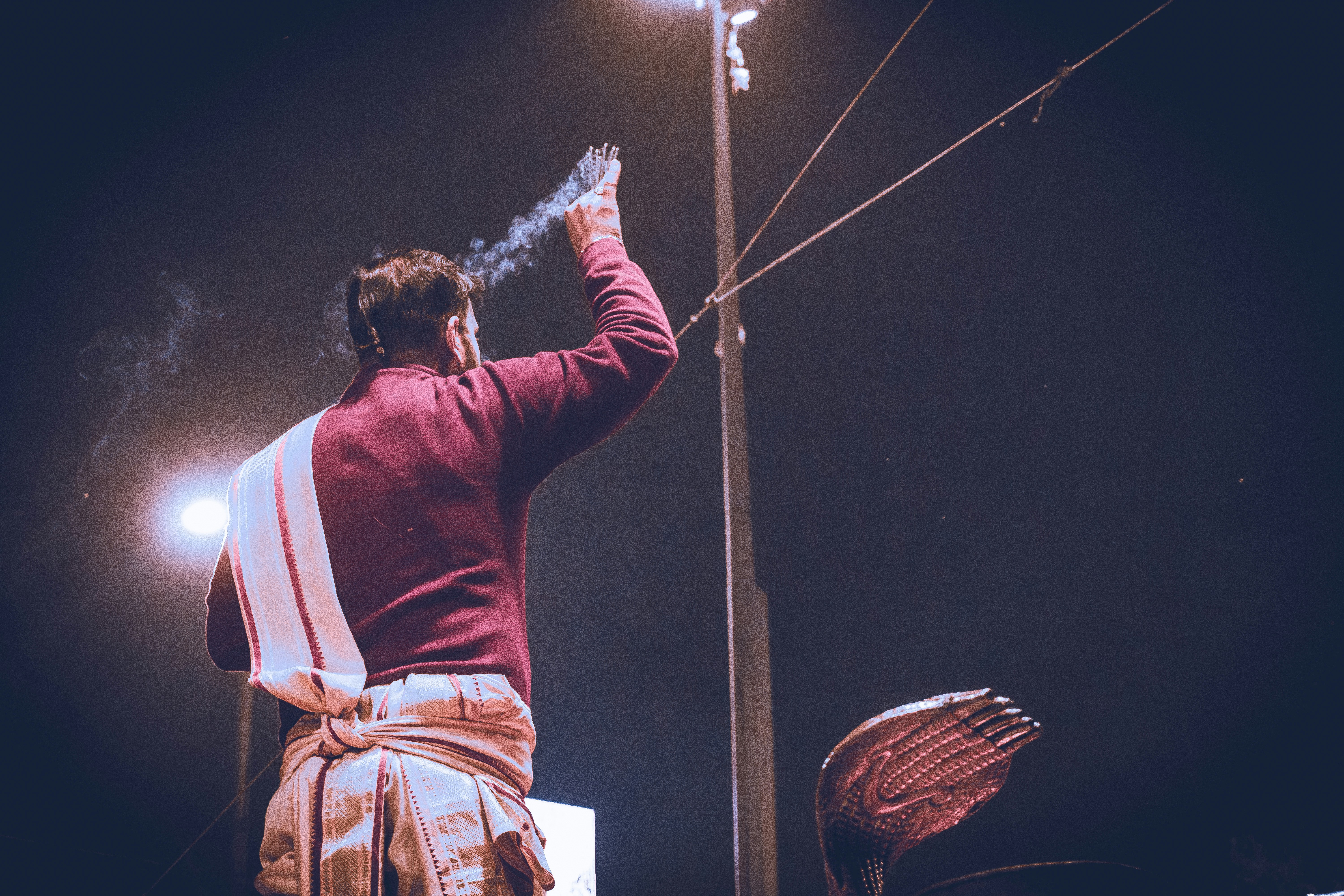 Man performing a ritual with smoke and light.