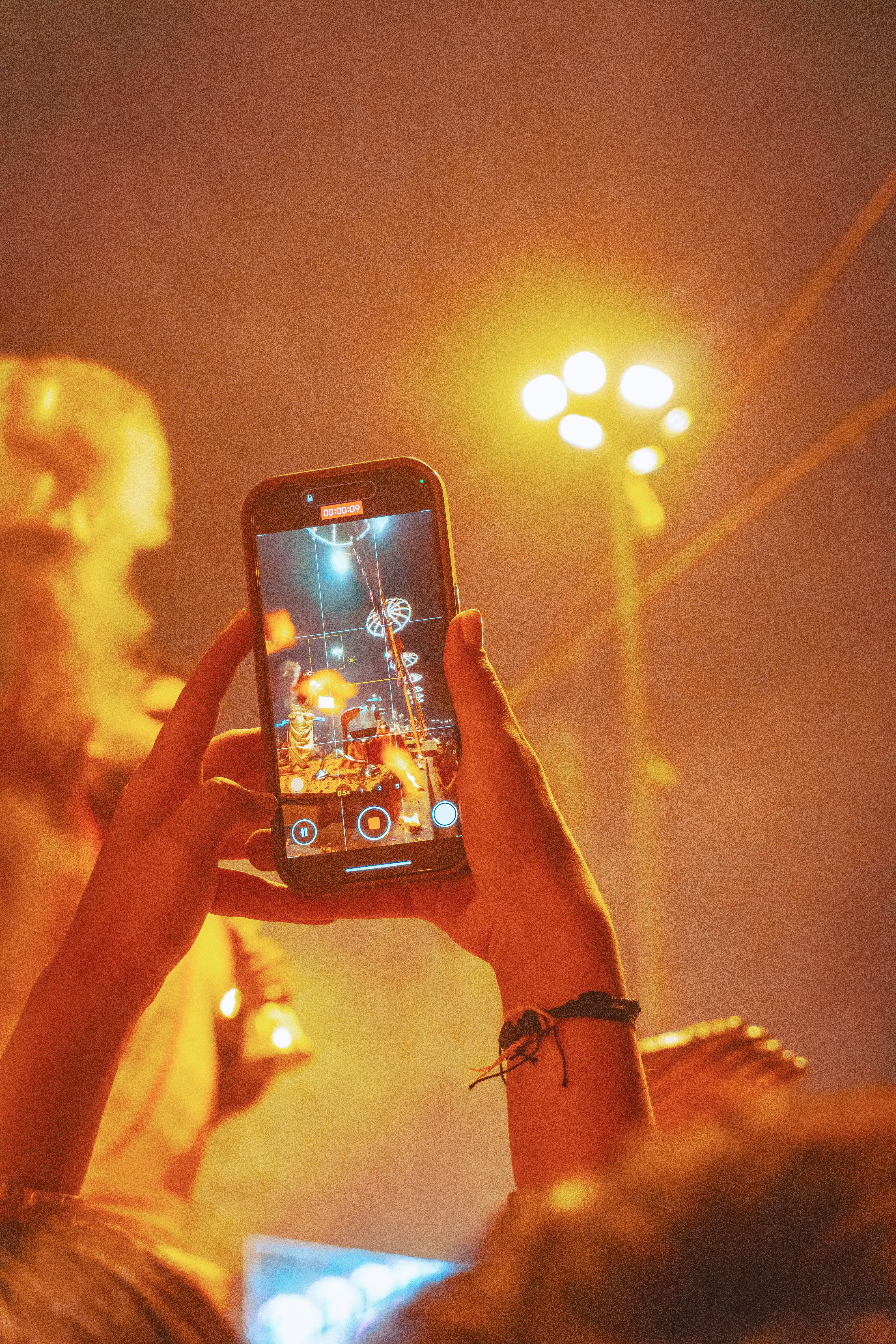 Person filming a concert with a smartphone