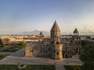 Ancient stone monastery with snow-capped mountain background.