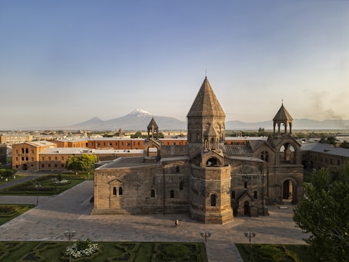 Ancient stone monastery with snow-capped mountain background.