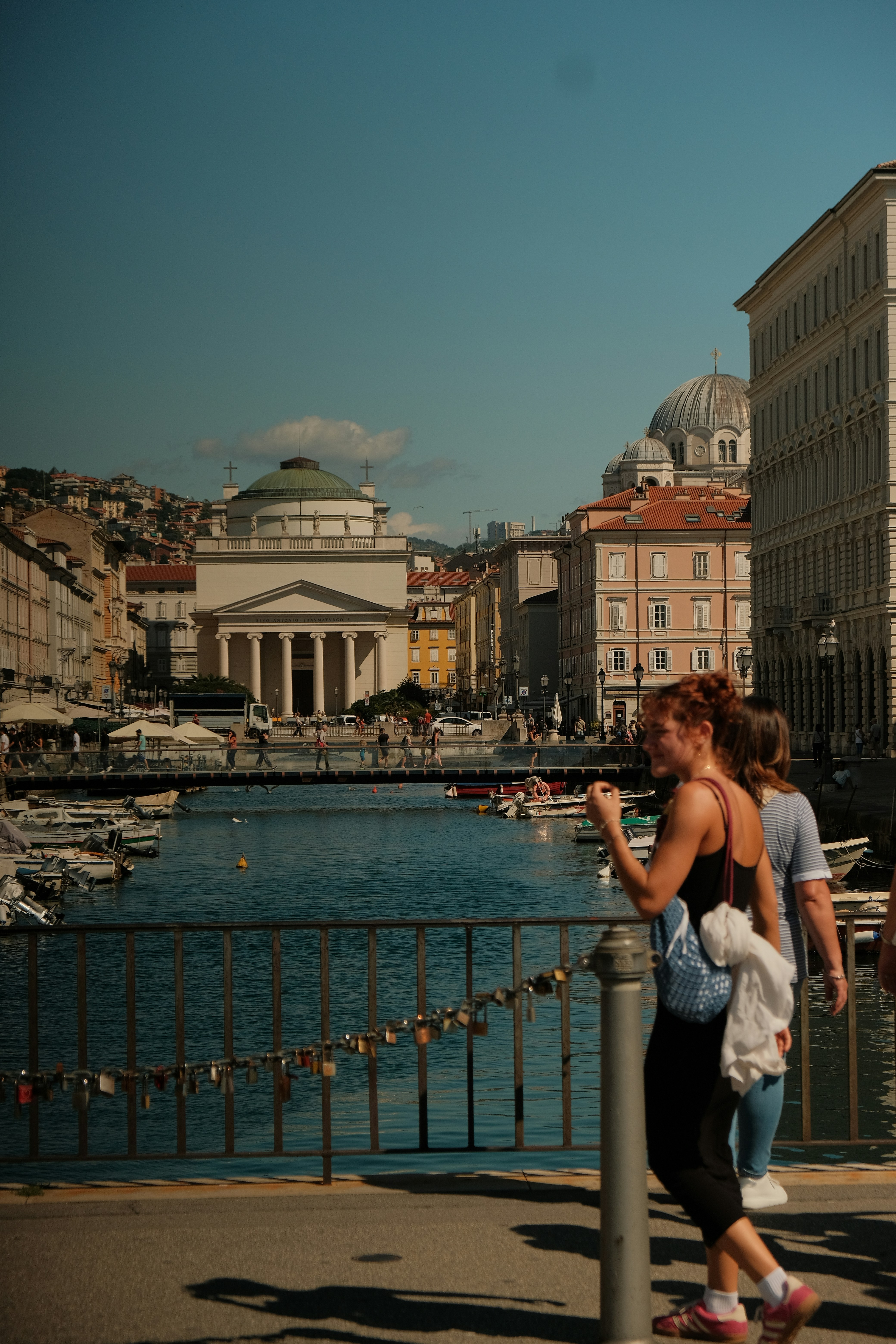 People walk by a canal in a european city.