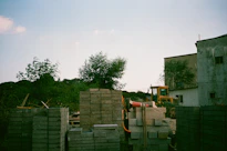 Construction site with stacked bricks and bulldozer.