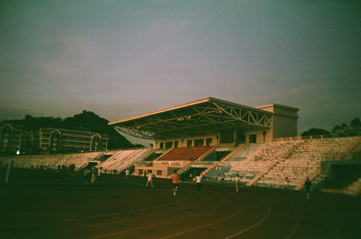 Athlètes en course sur une piste de stade, photographie argentique noir et blanc