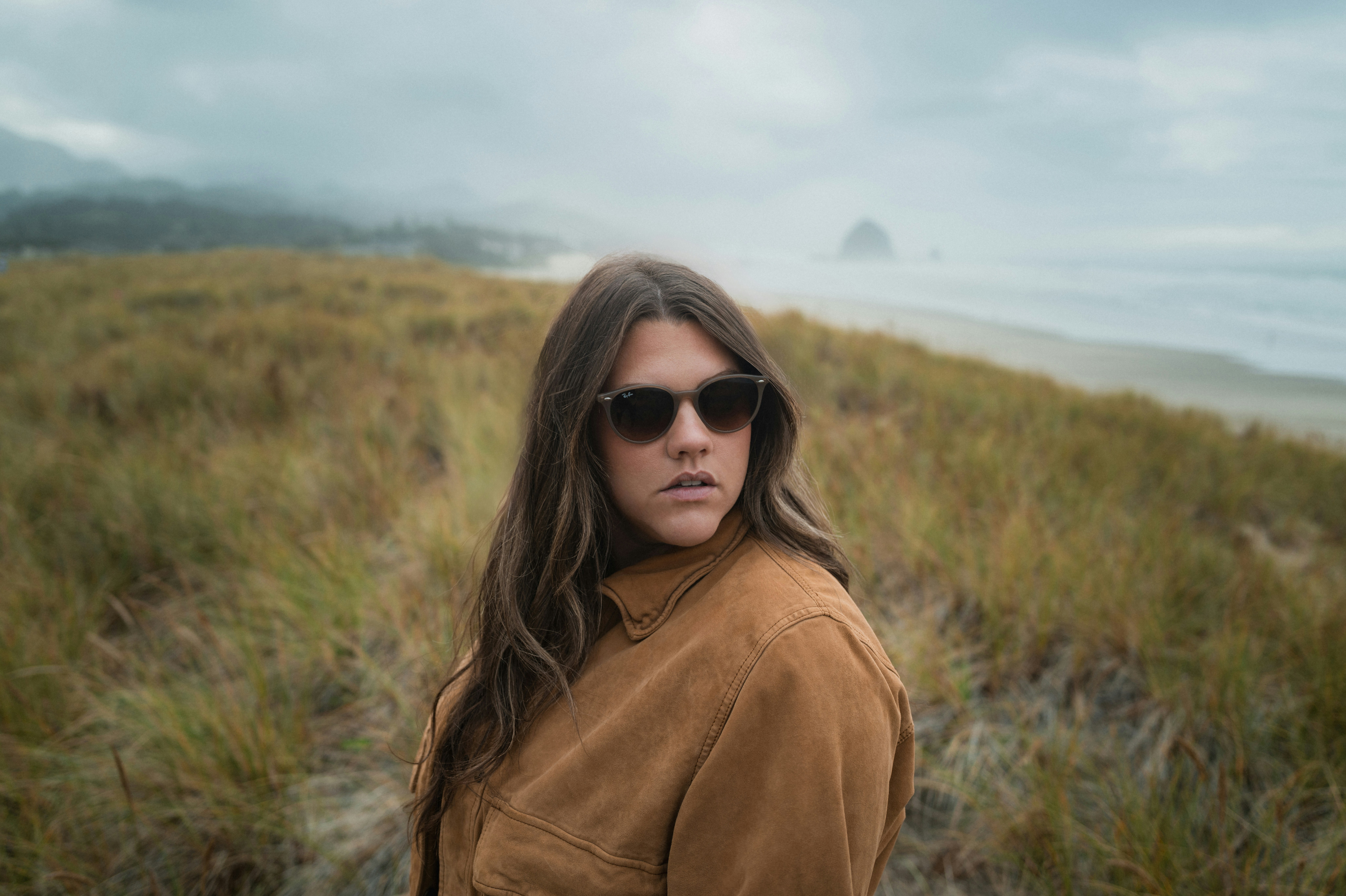 Donna che indossa occhiali da sole su una costa erbosa