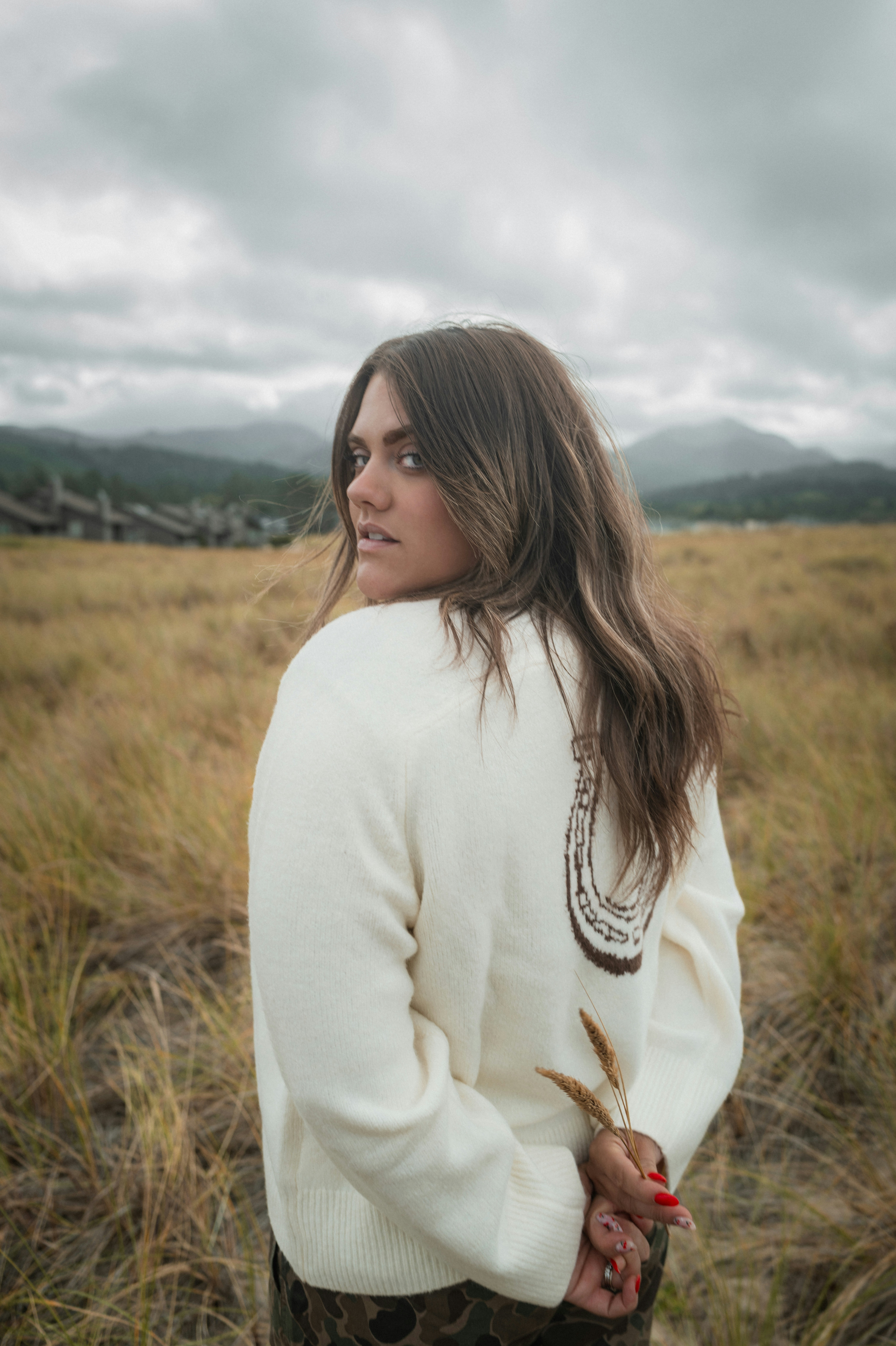 Donna in maglione che guarda oltre la spalla in campo
