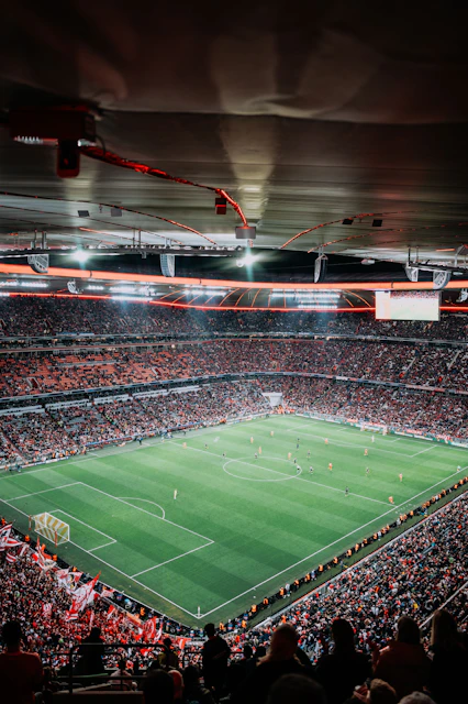 Soccer match in a packed stadium at night.