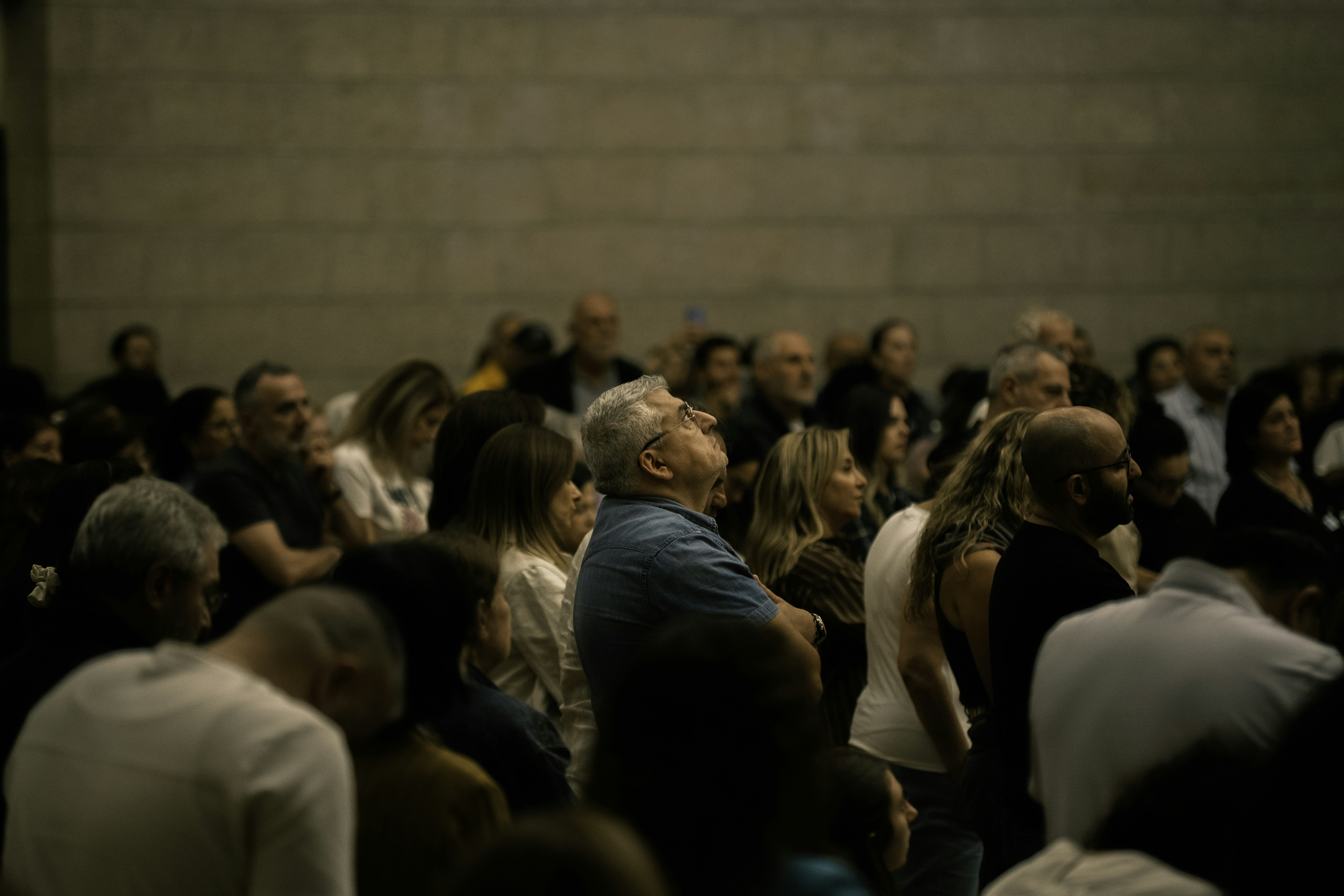 A diverse crowd of people looking upwards