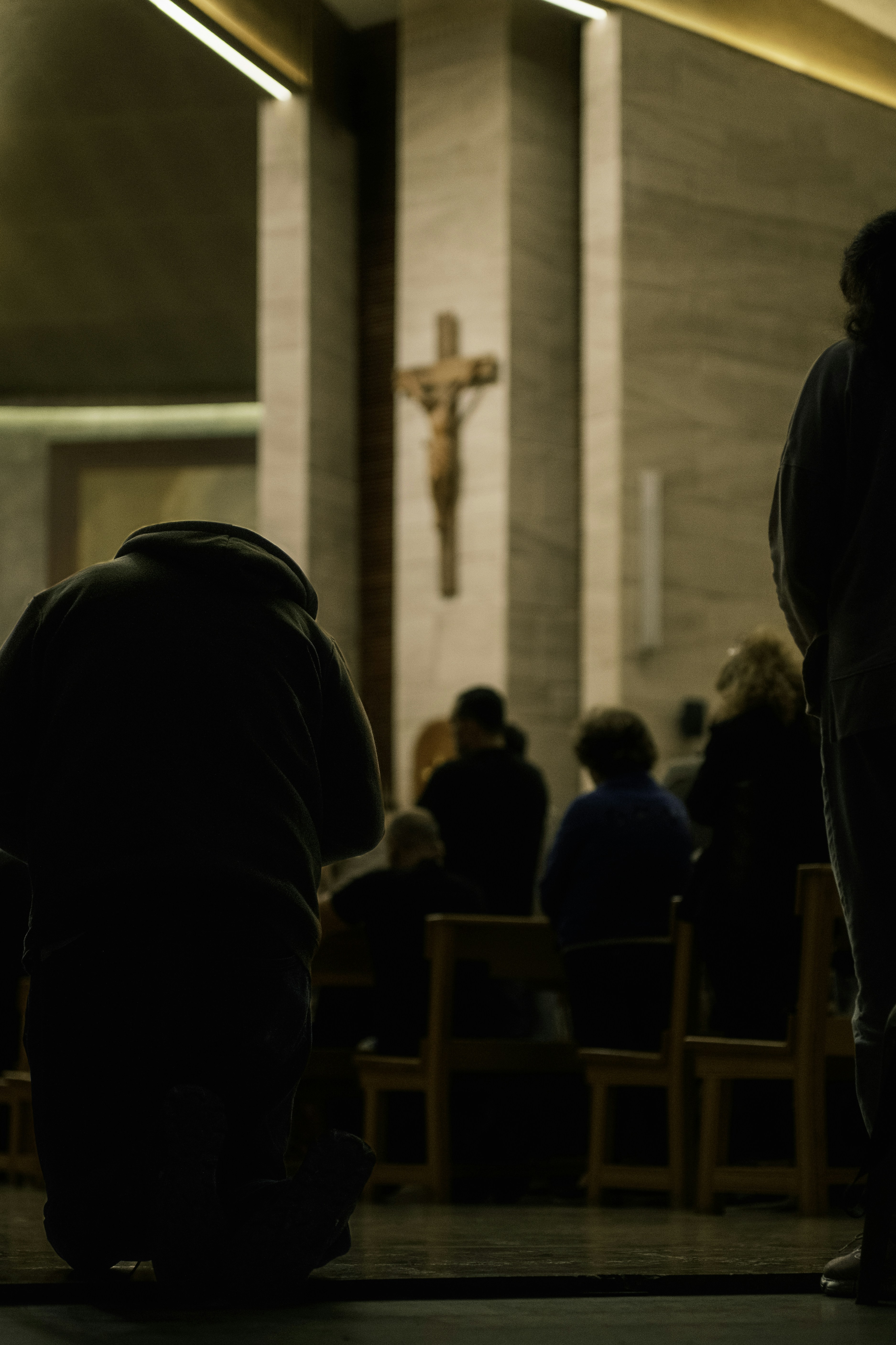People praying in a church before a crucifix.