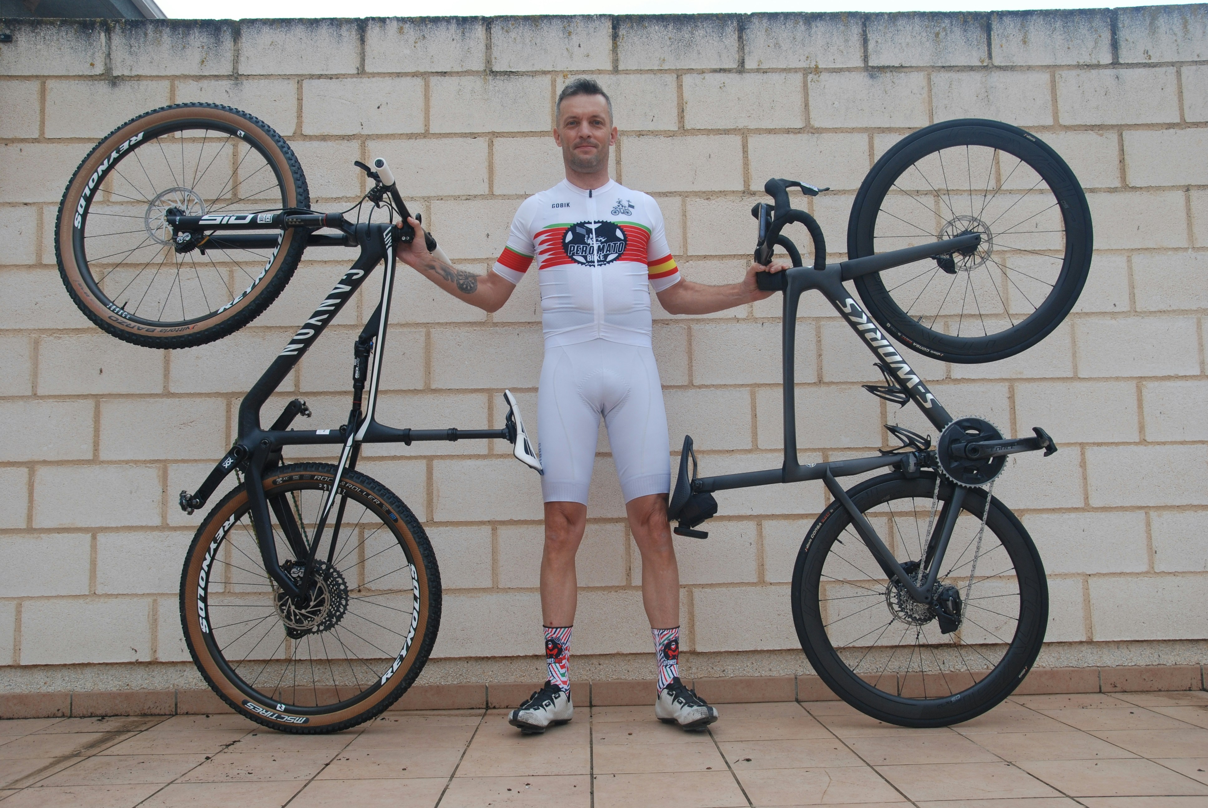 Man in cycling gear holding a tandem bicycle