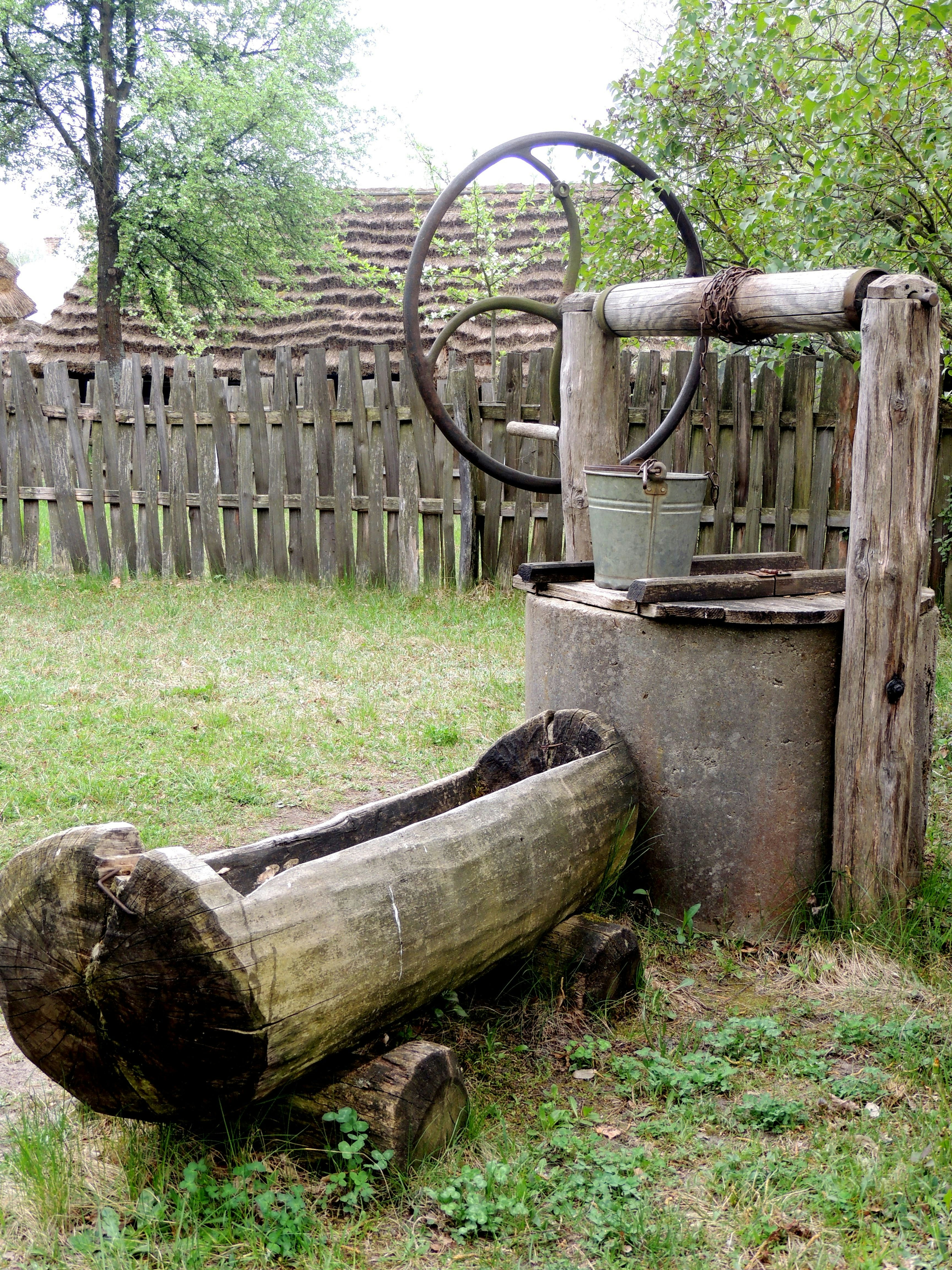 Old wooden well with a bucket and trough