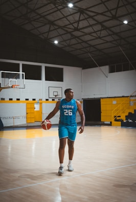 A man in a basketball uniform dribbling a ball