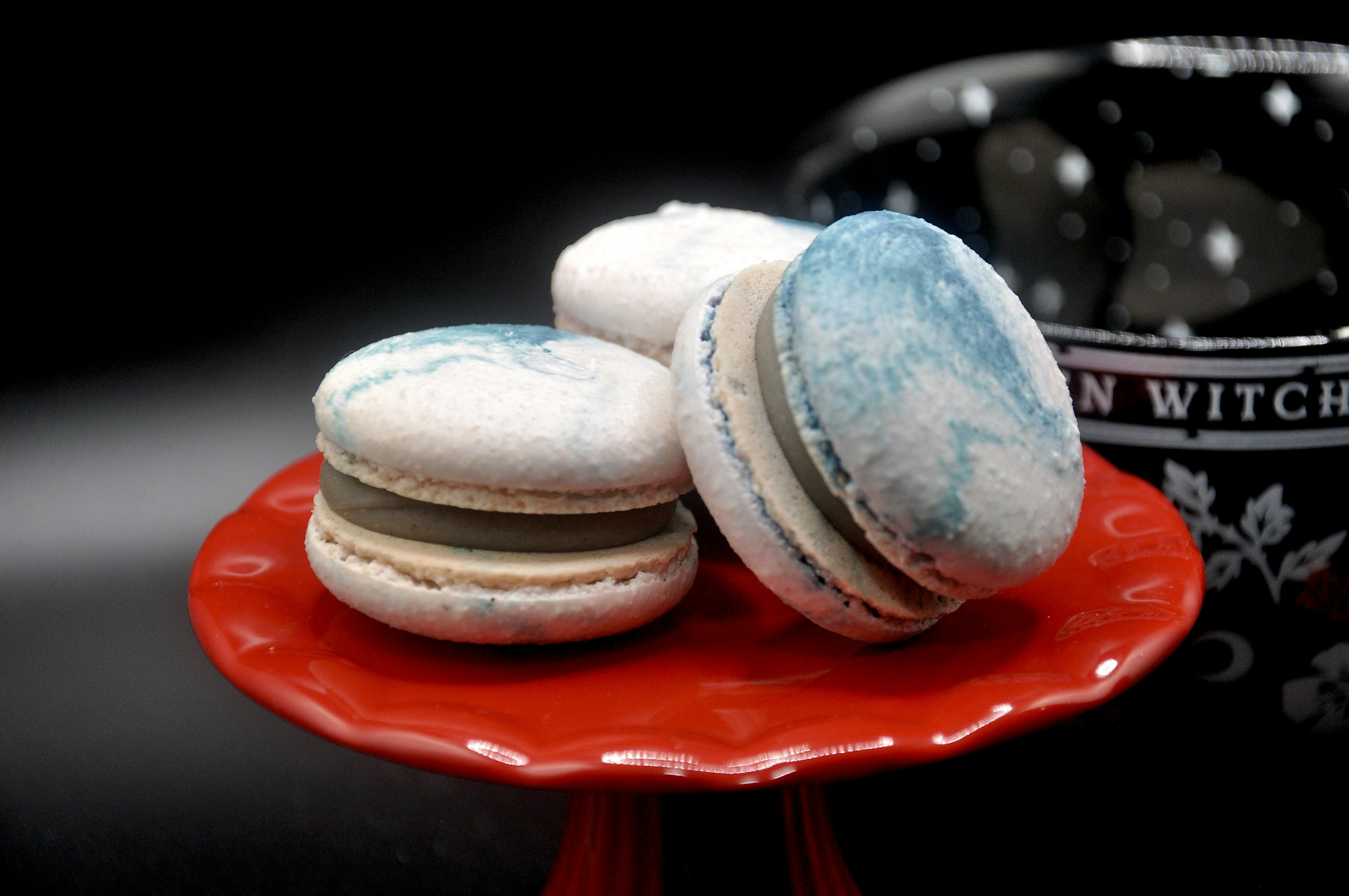 Three macarons on a red cake stand