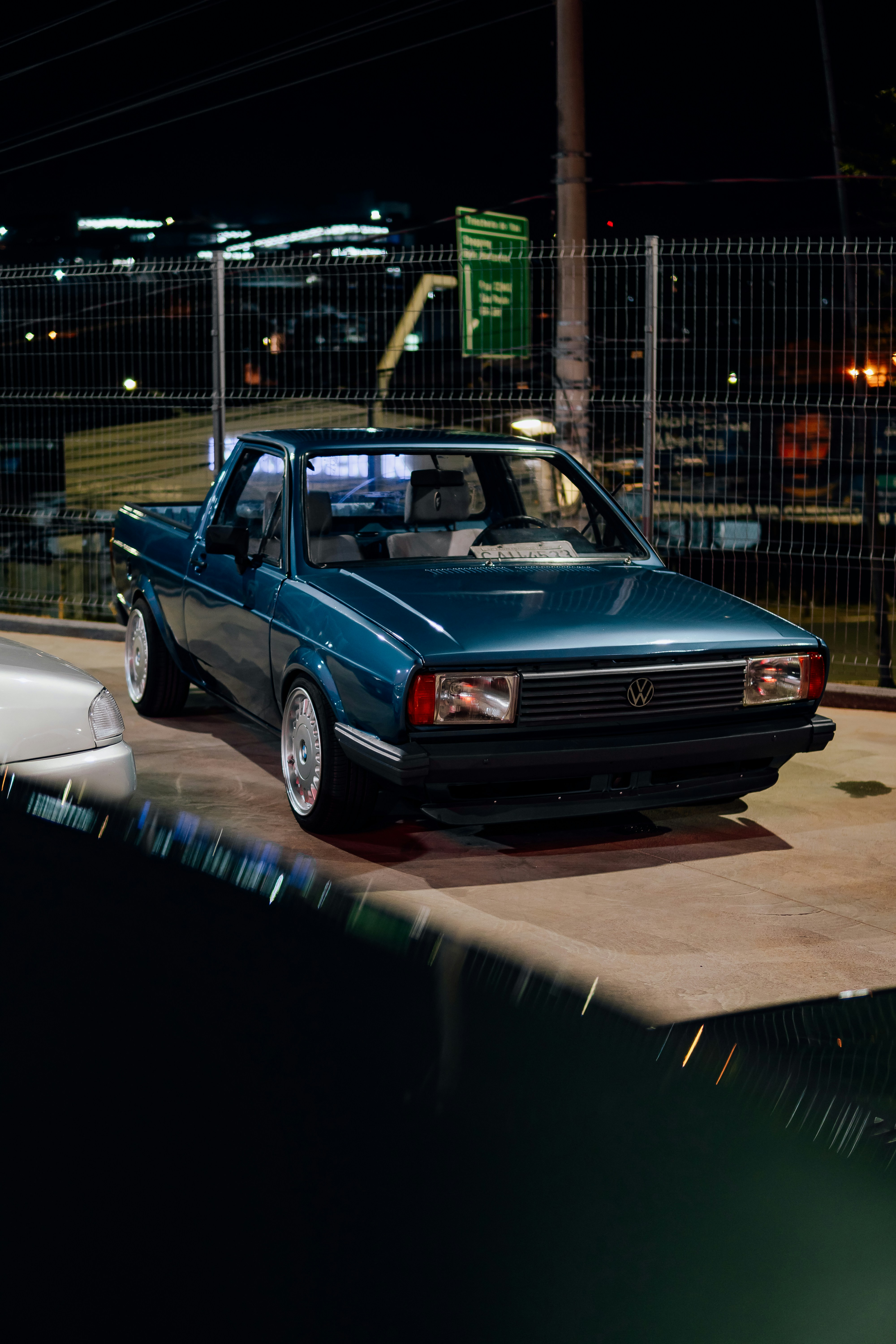 A teal pickup truck parked at night