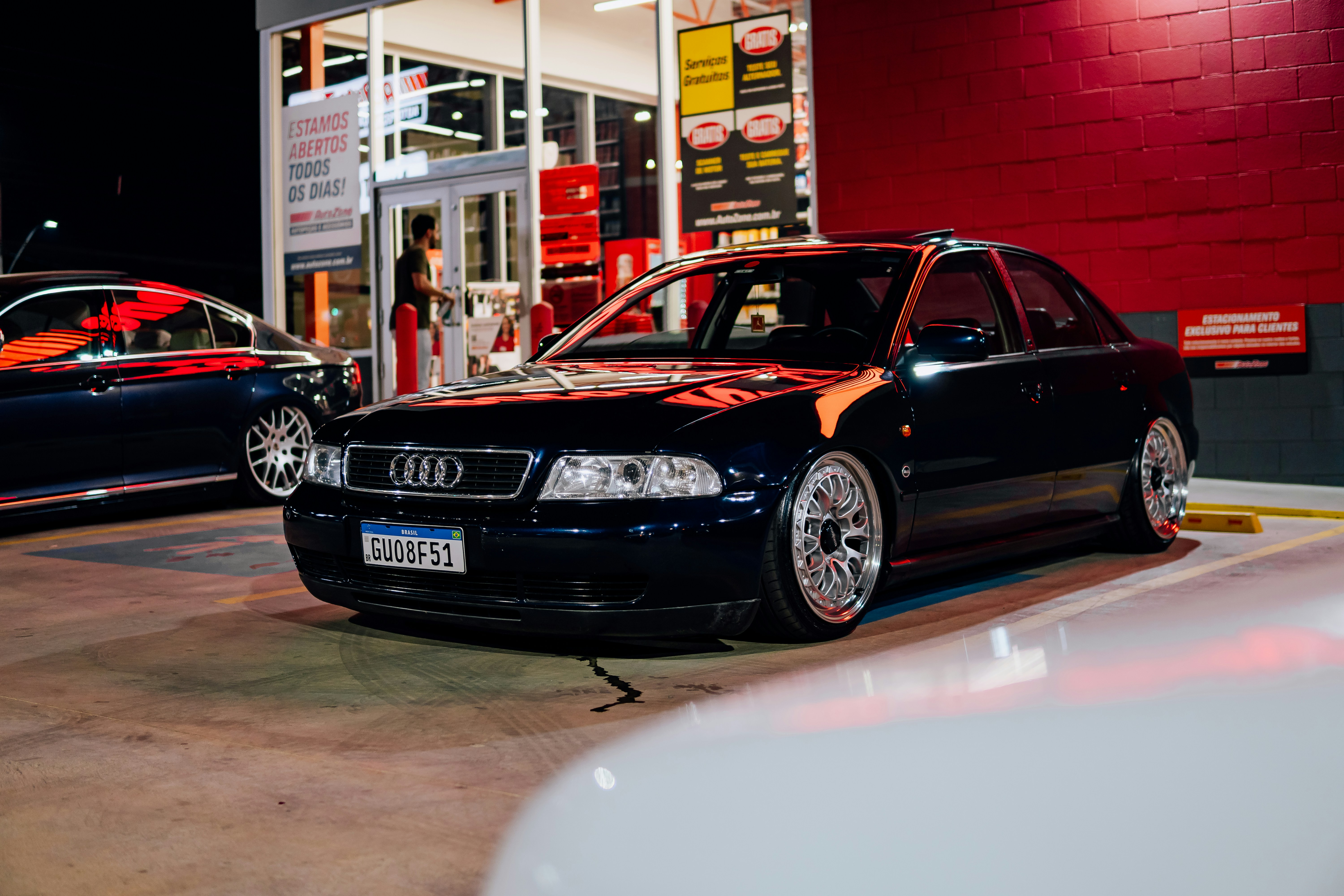 Dark sedan parked outside a building at night