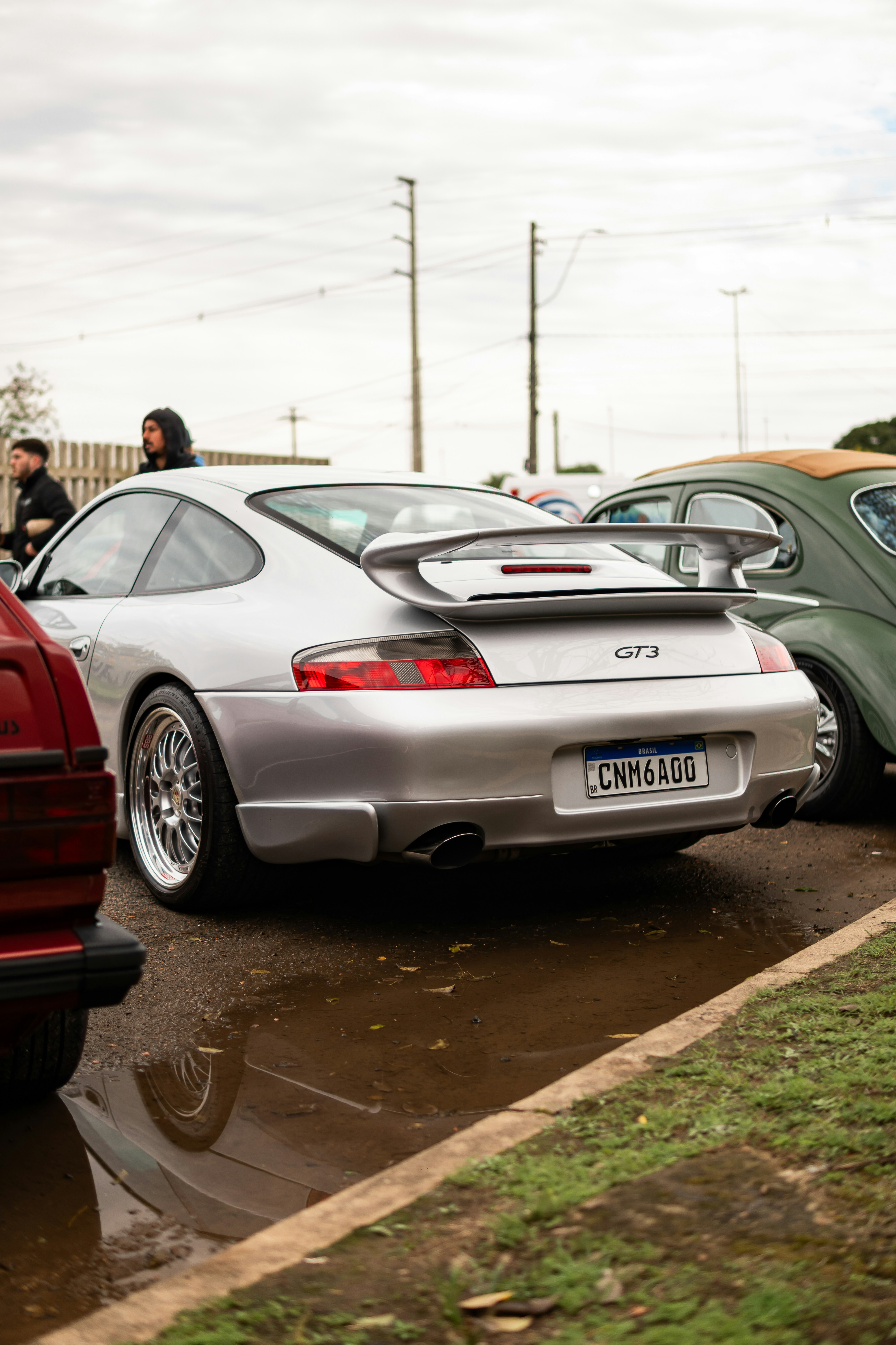 Silver porsche gt3 parked on wet asphalt