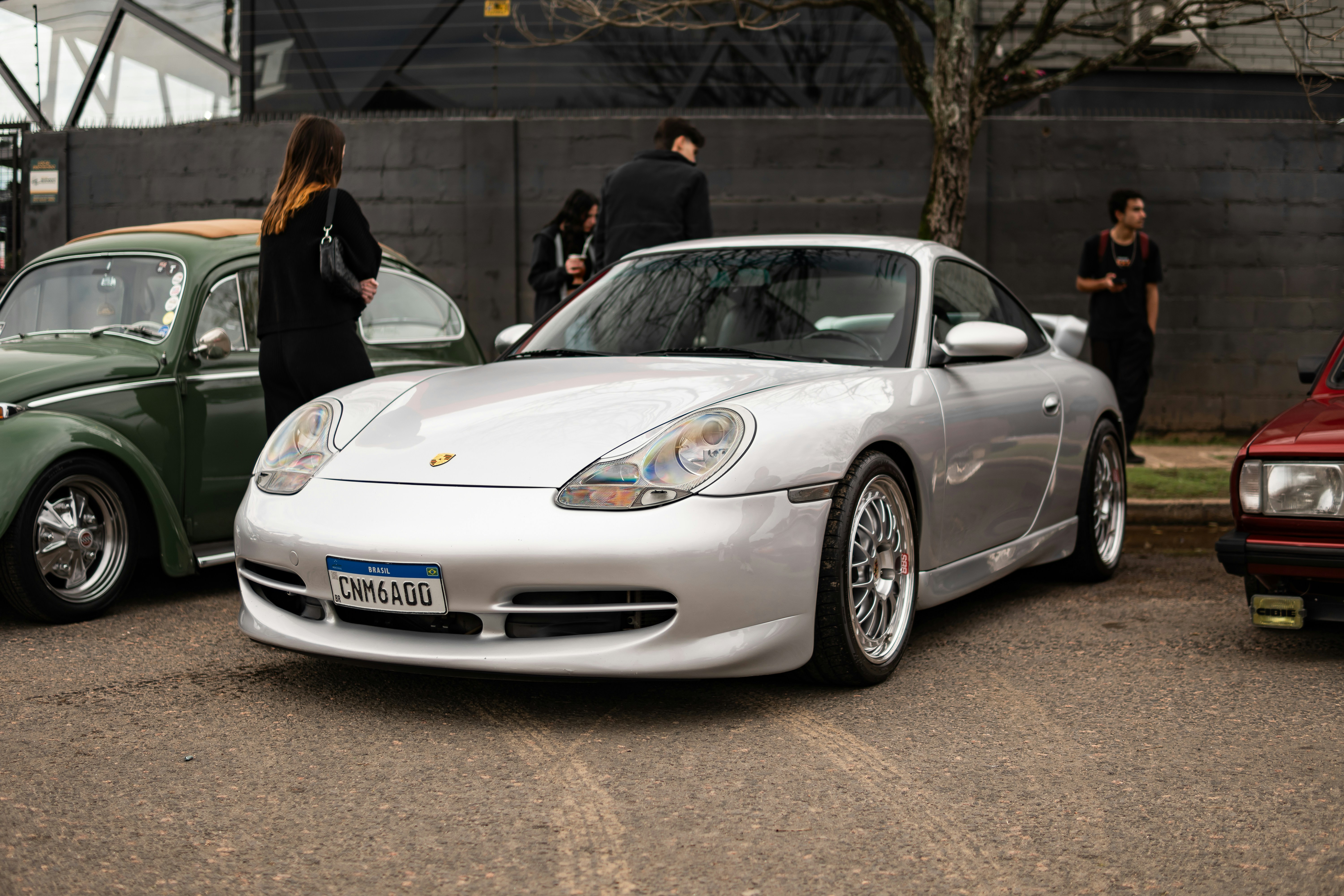 Silver porsche parked with other cars
