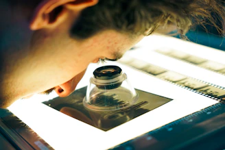 Person examining film negatives with a loupe.