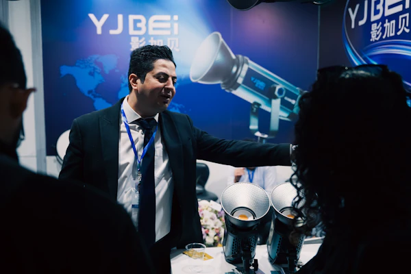 Orlando trade expo venue - Man in suit presenting equipment at a trade show.