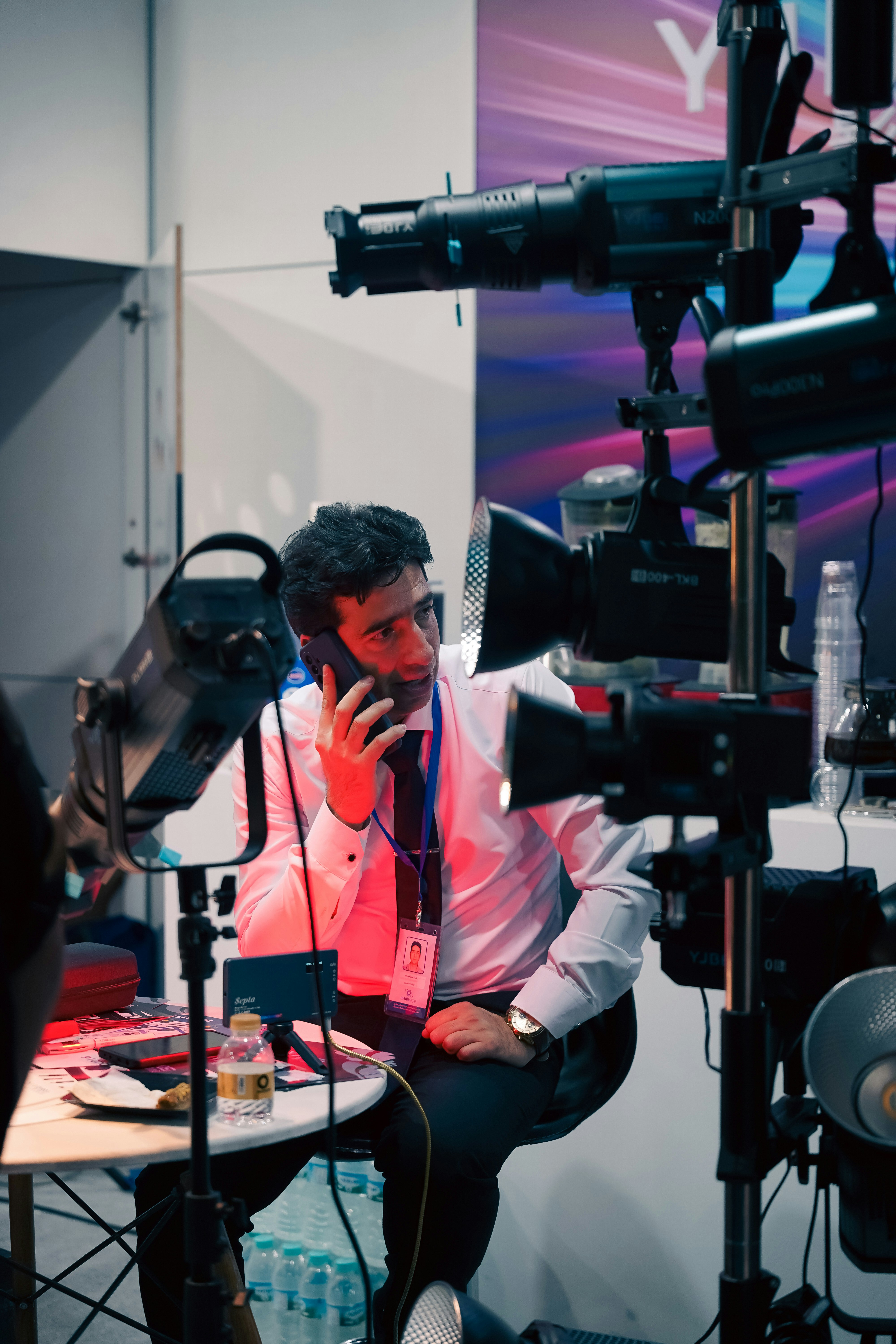 Man in shirt talking on phone near studio lights