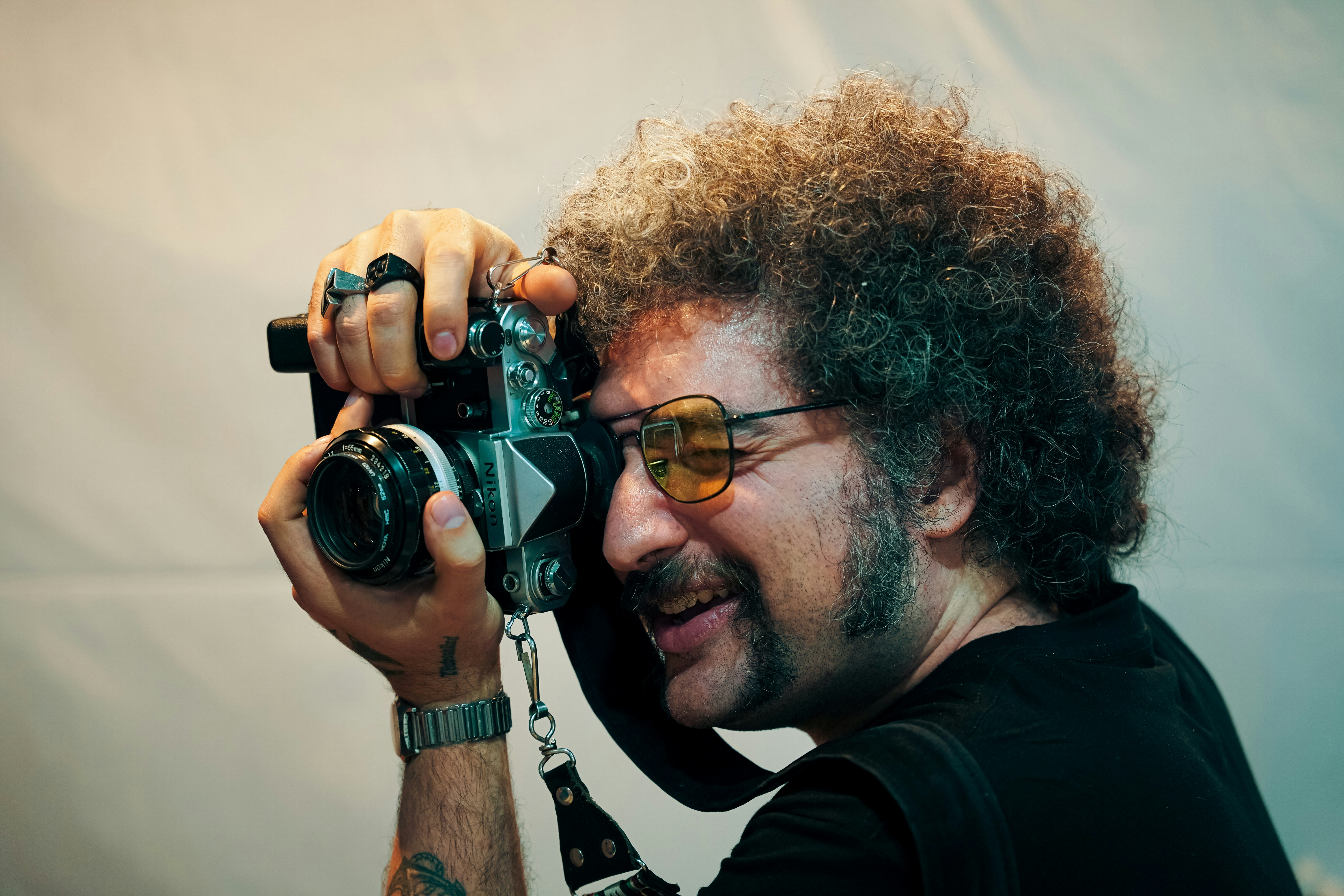Pria dengan afro memegang kamera vintage