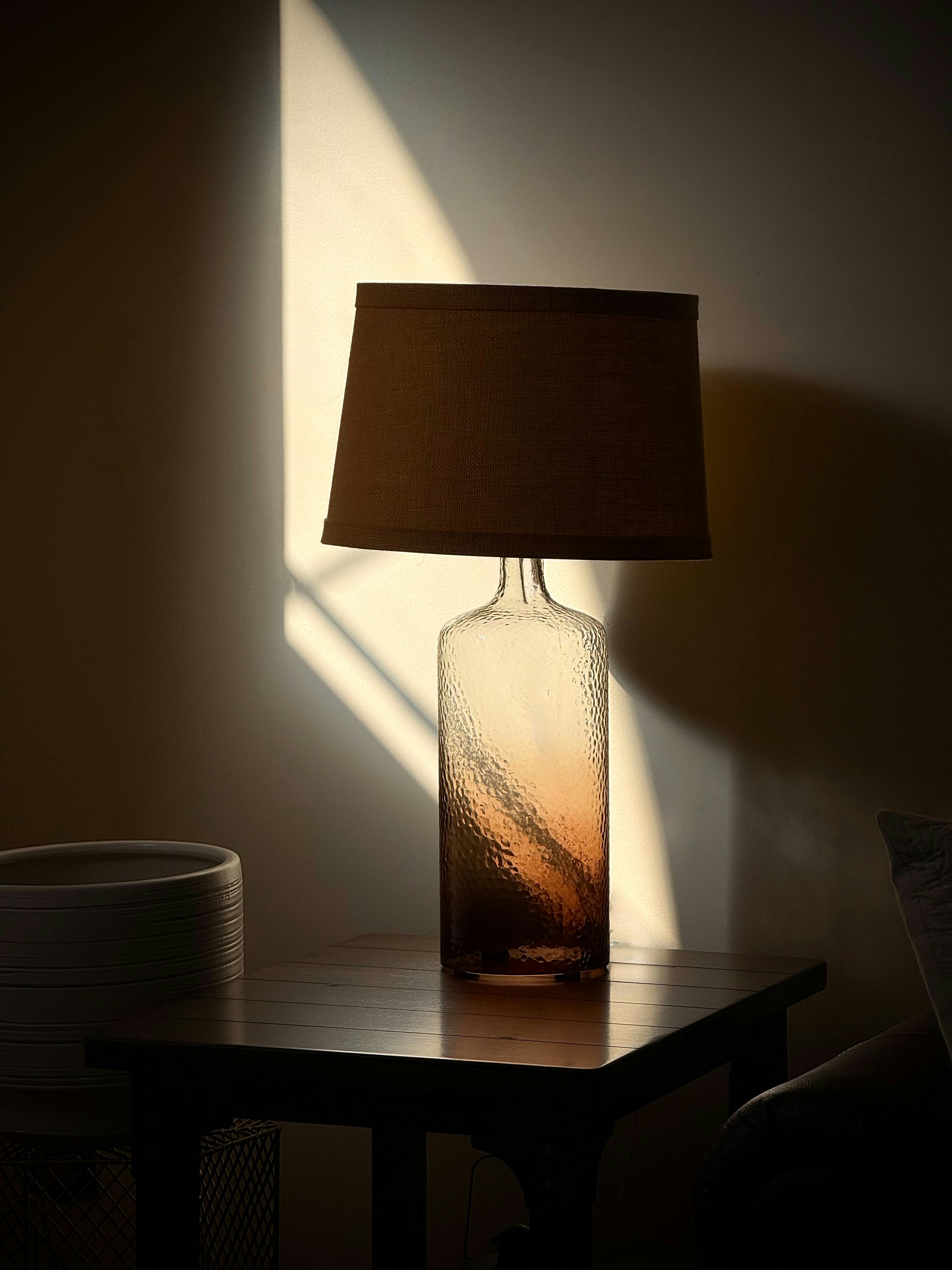 Lamp on a table with dramatic sunlight.