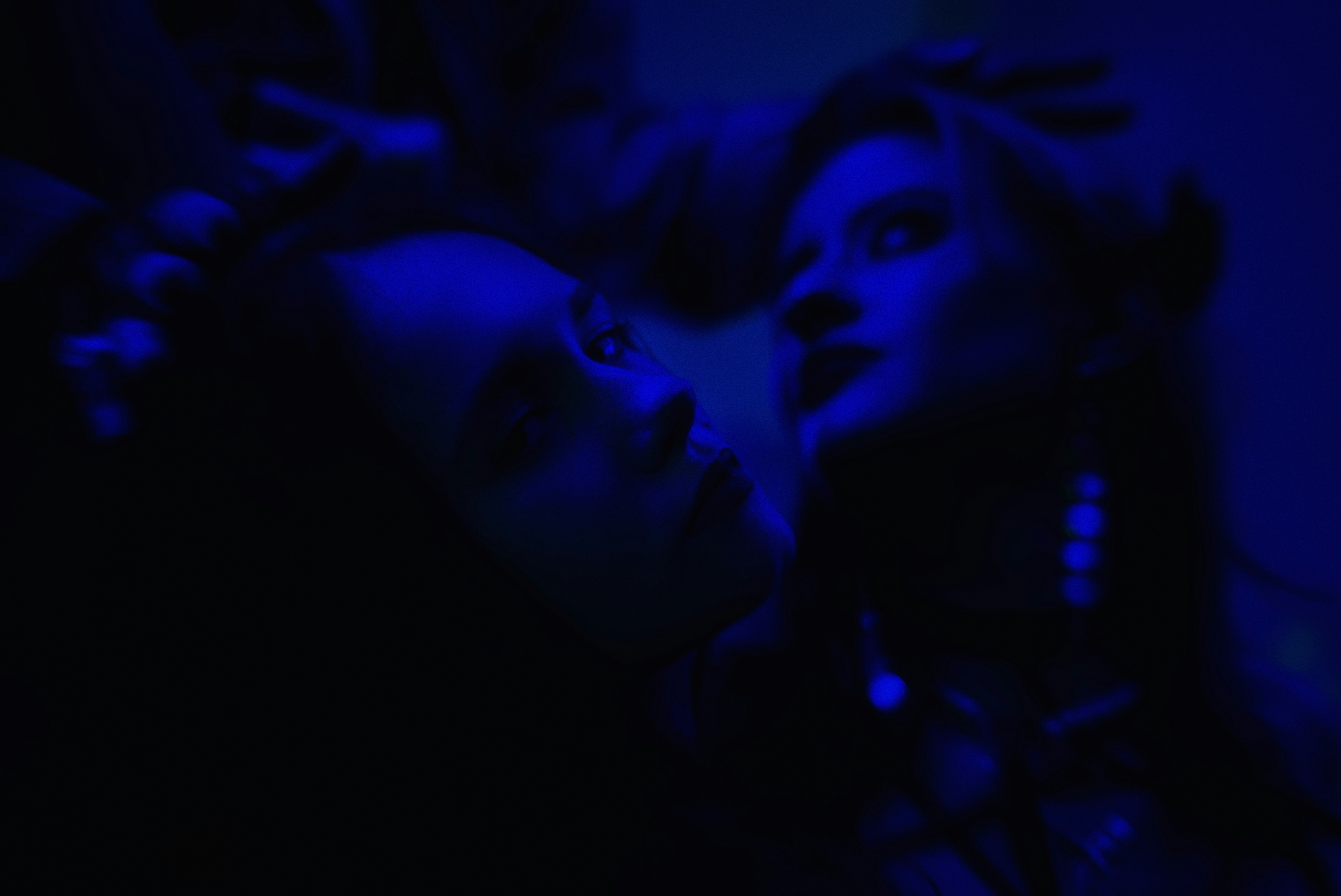 Two people illuminated by blue light