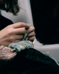 Hands knitting a colorful yarn project
