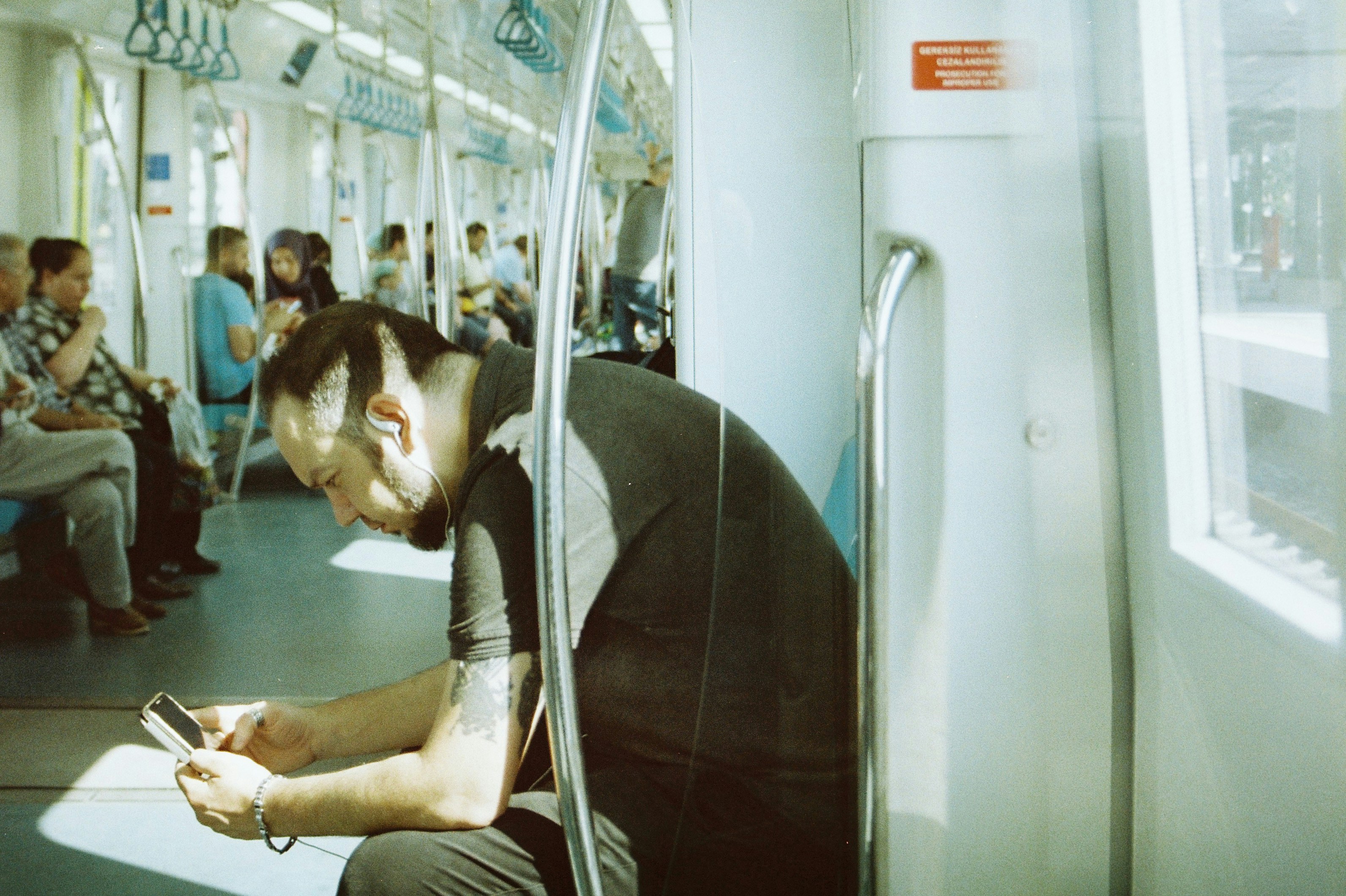 Pria menggunakan telepon di kereta yang ramai