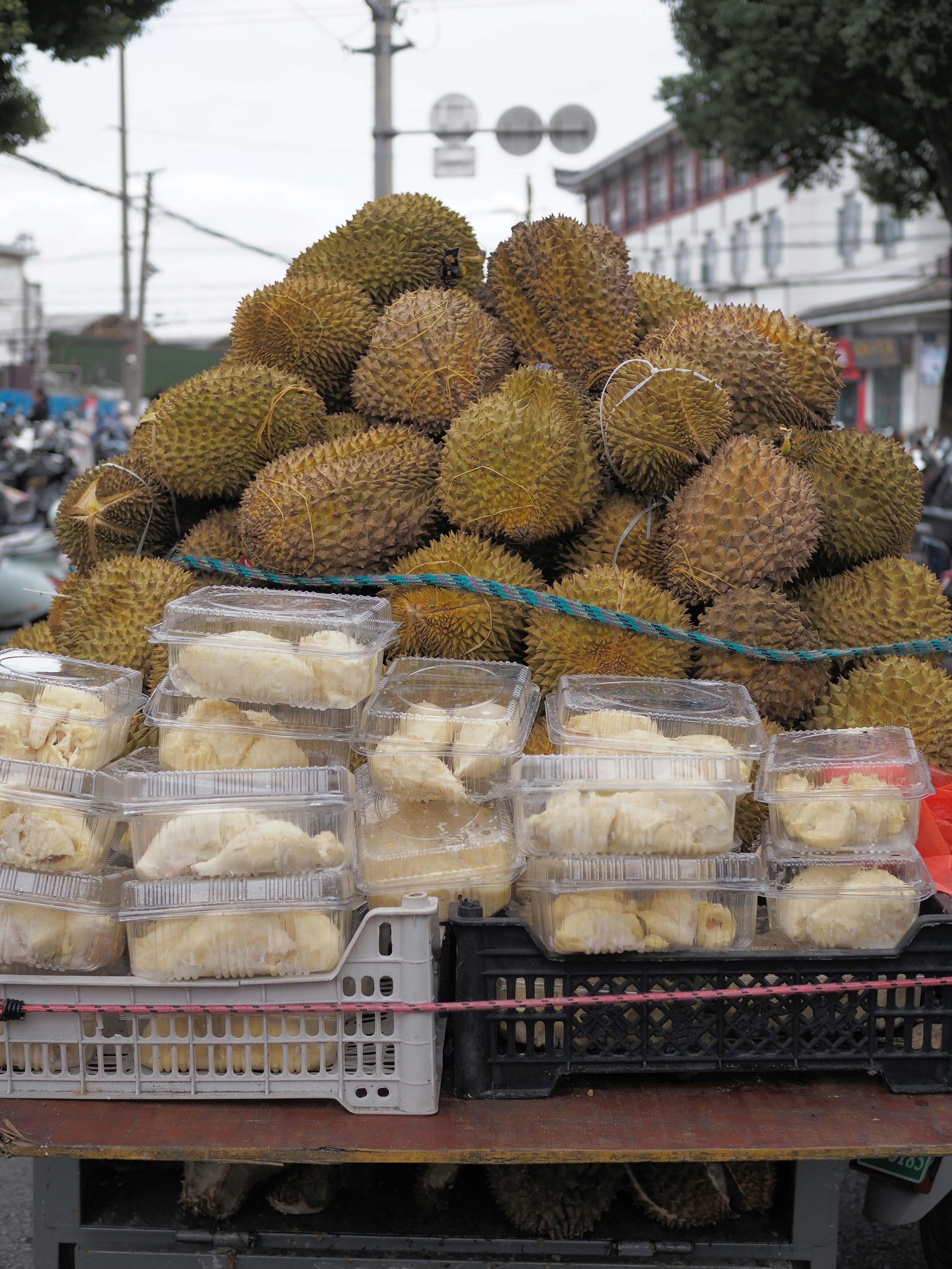 Pile of durian fruits and pre-cut durian portions.