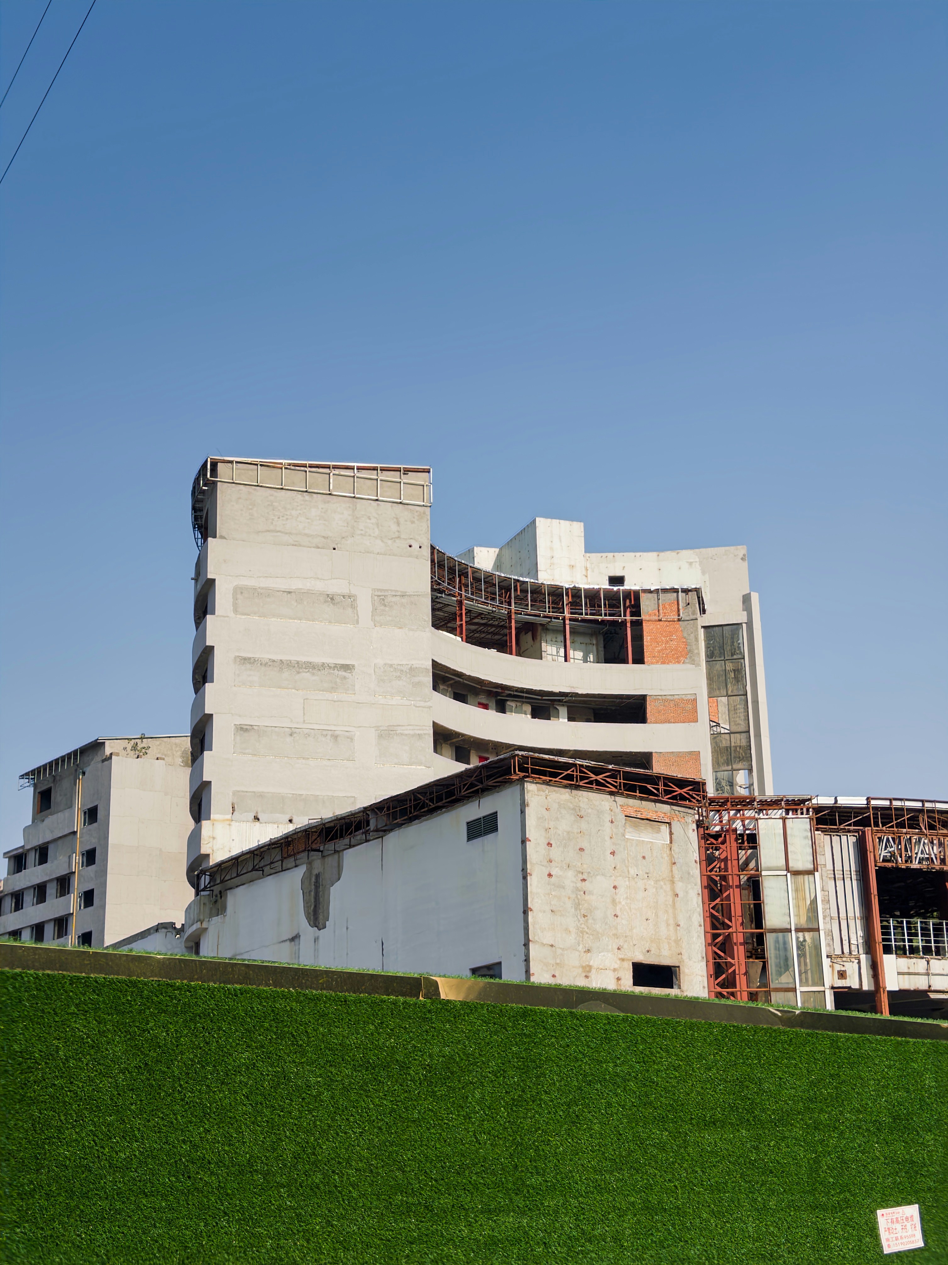 Unfinished concrete buildings against a clear blue sky.