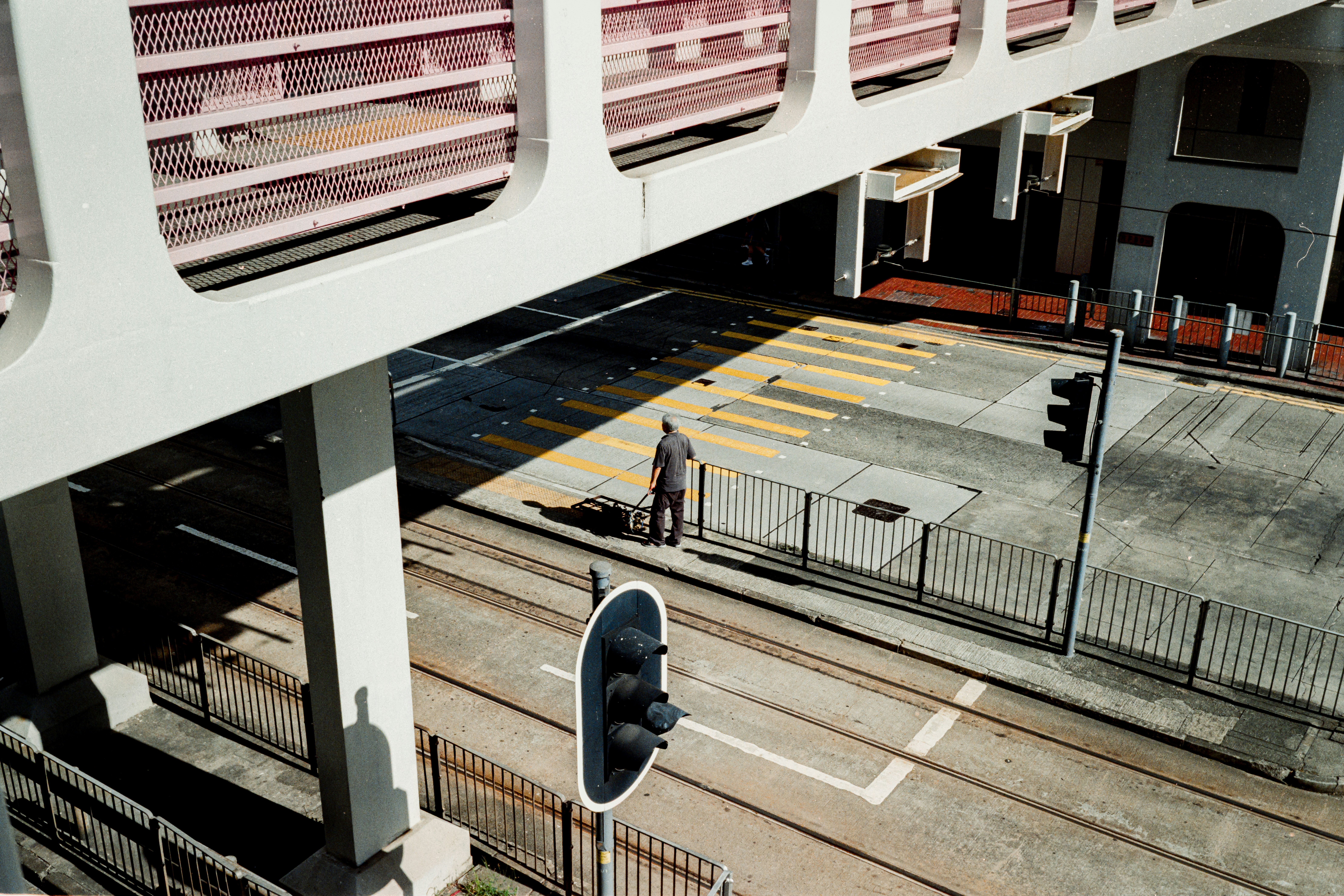 Man standing at tram tracks near crosswalk