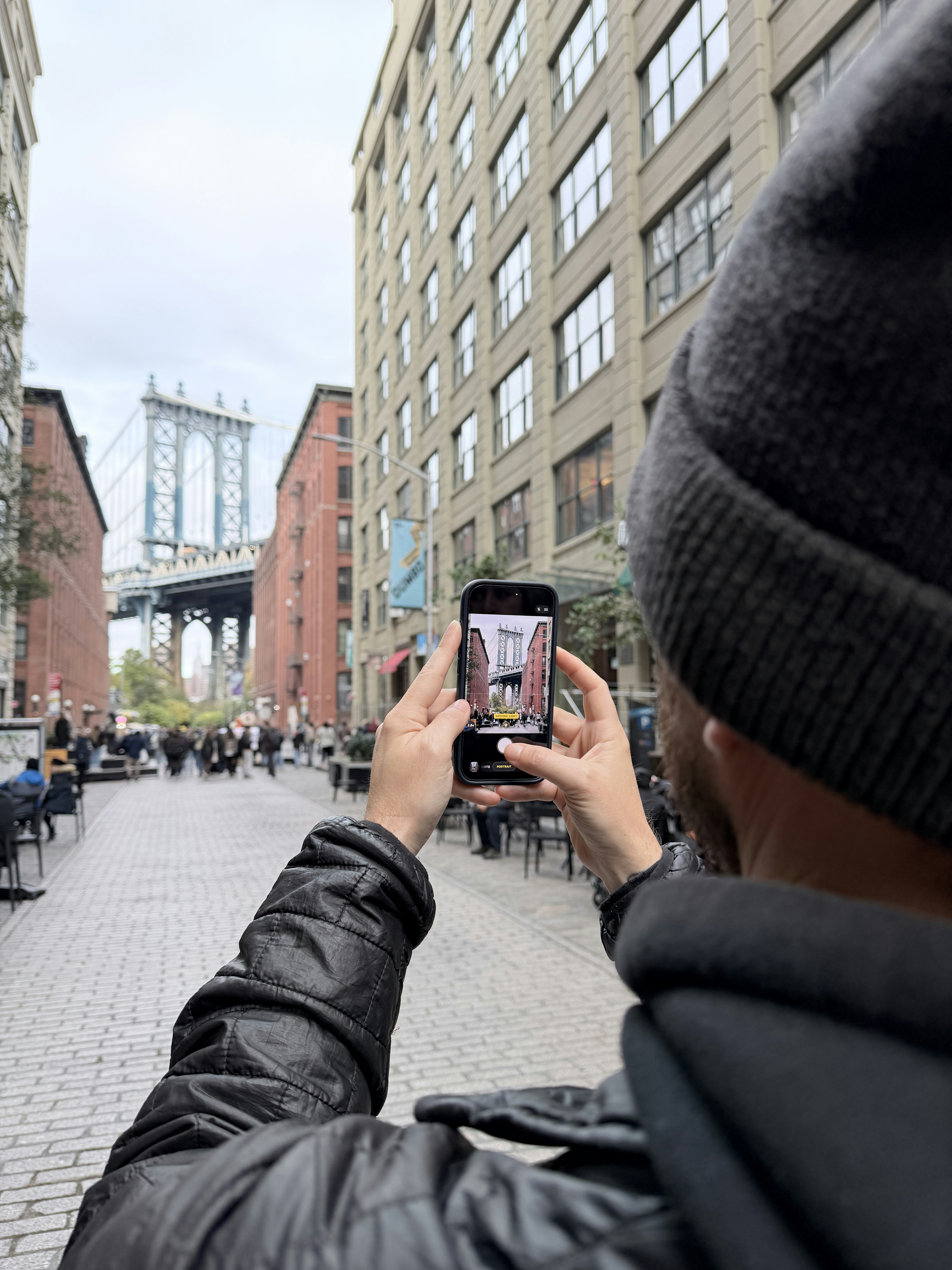 Man photographs manhattan bridge with smartphone