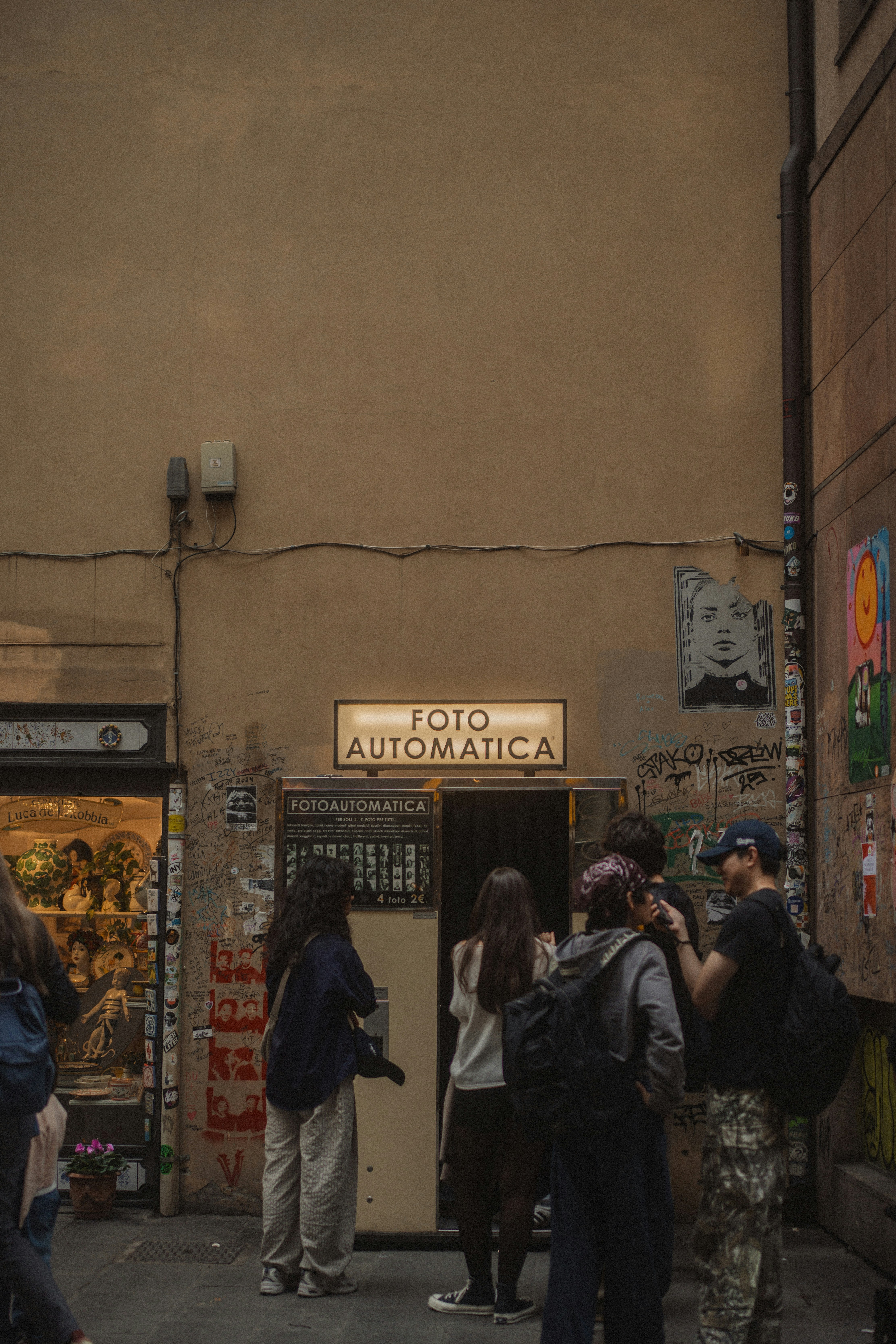 As pessoas fazem fila para uma cabine de fotos automática.