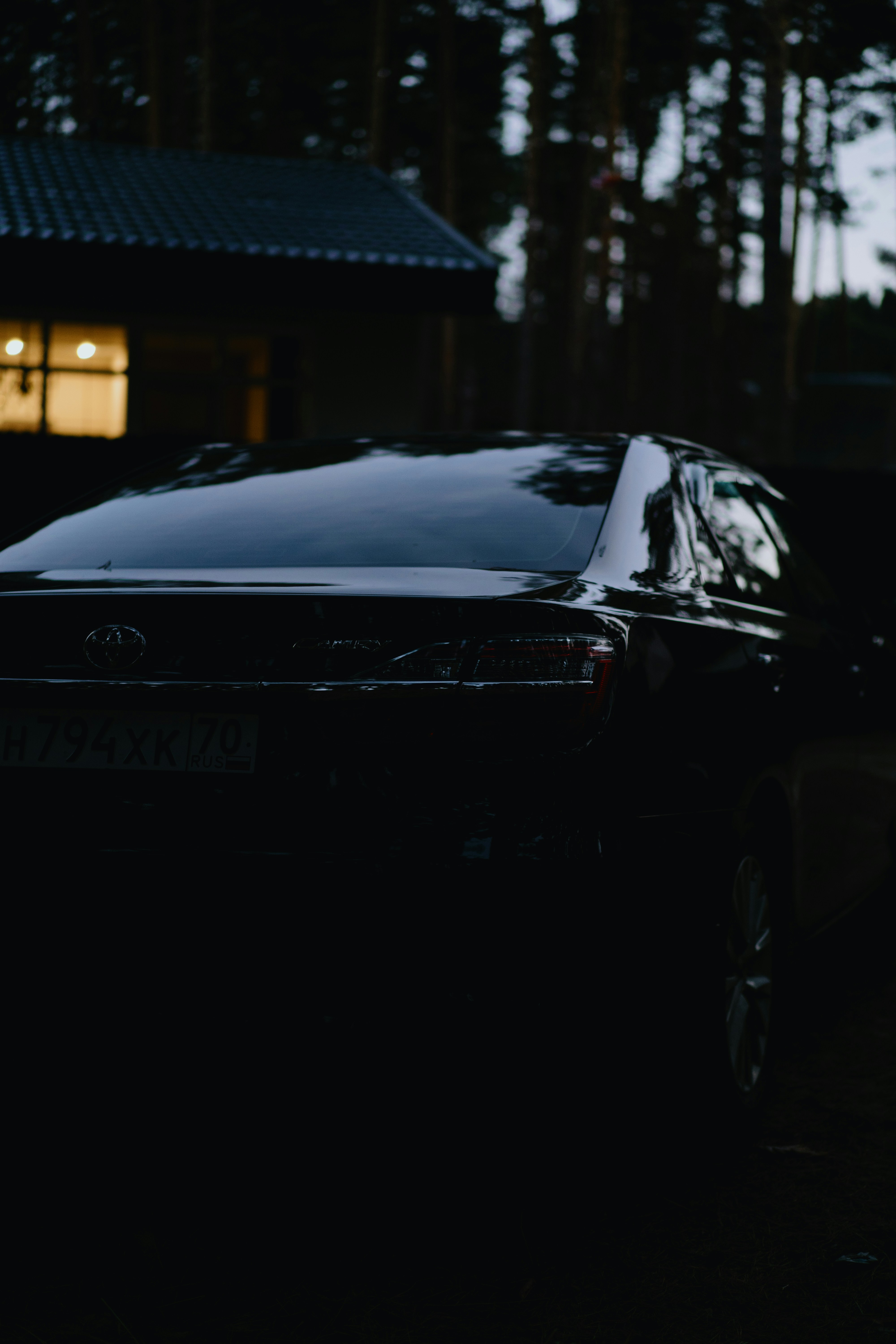 Berlina scura parcheggiata vicino a una casa di notte