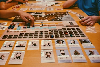 People playing a board game with cards and pieces.