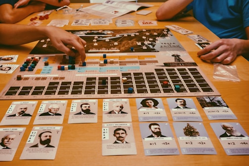 People playing a board game with cards and pieces.