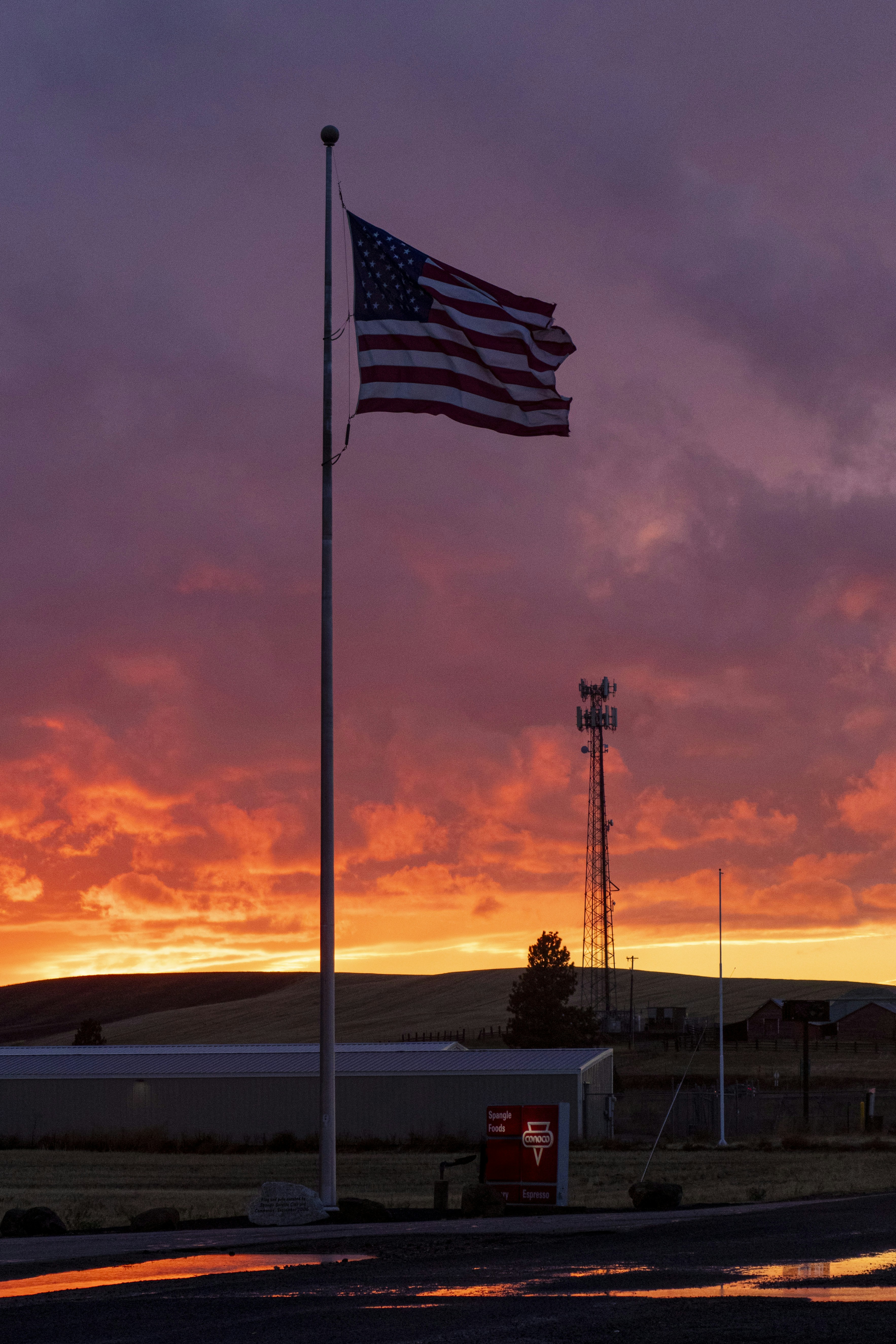 American flag waves against a vibrant sunset sky