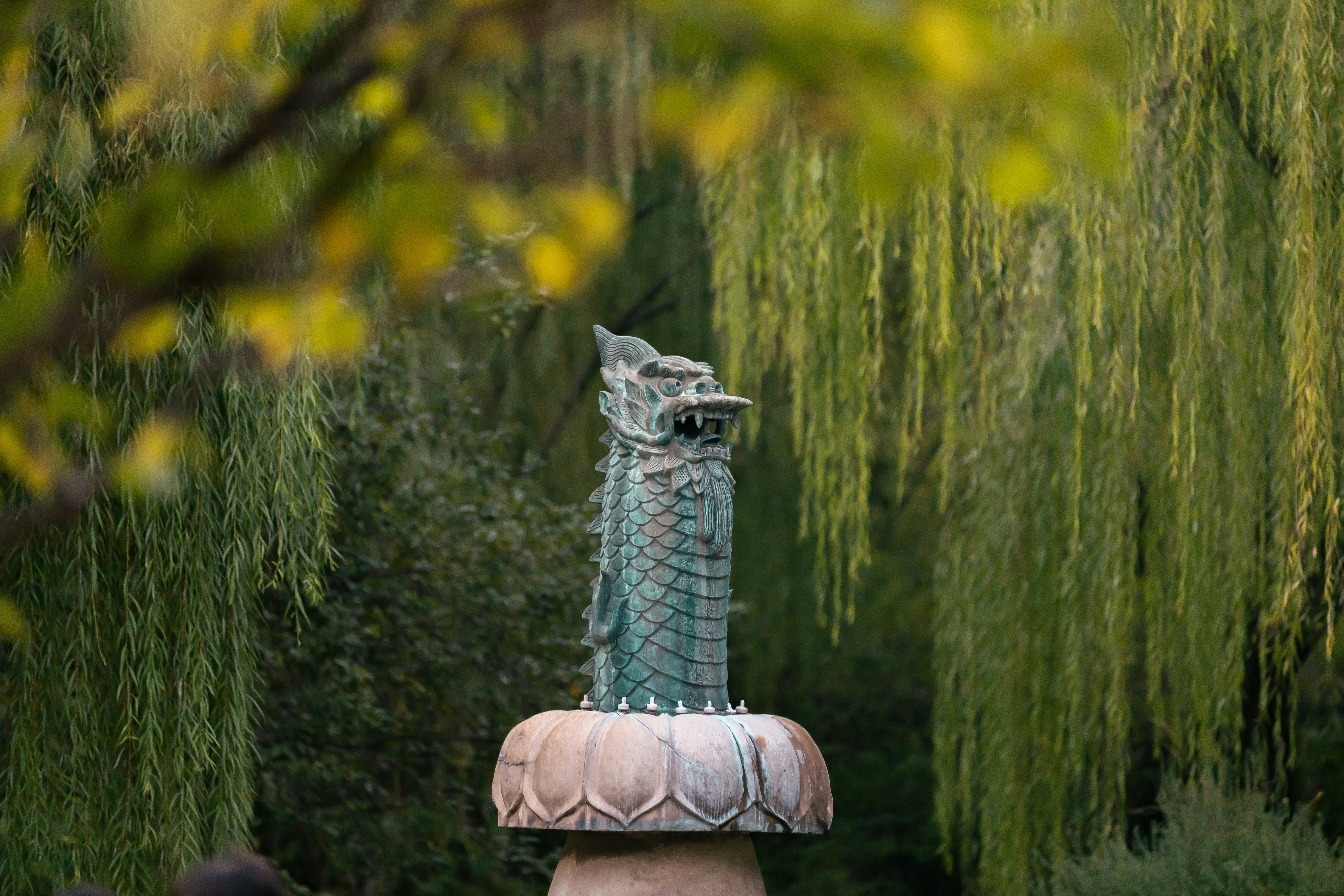 しだれ柳のある公園にある龍の像