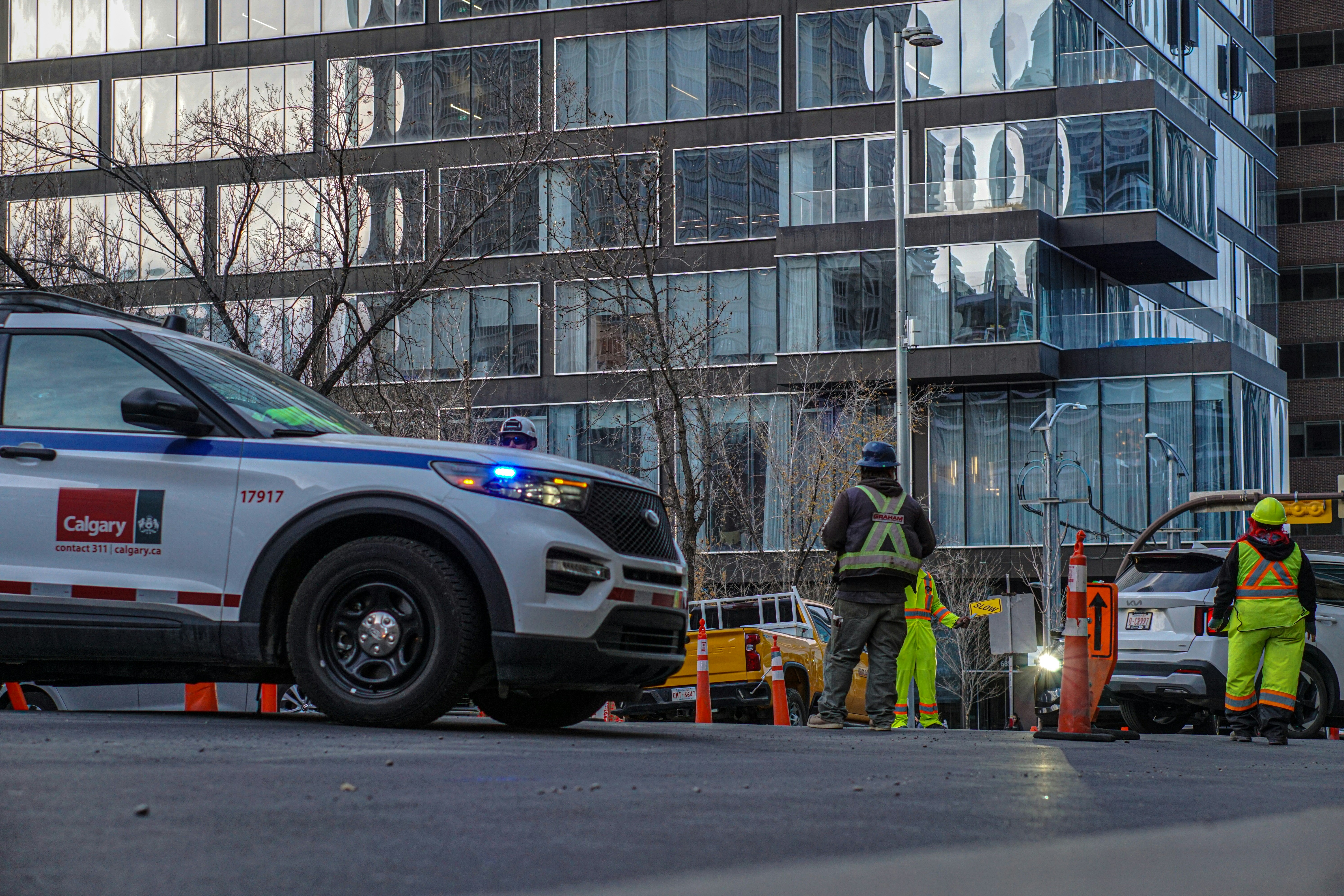 Polizeiauto und Arbeiter bei einer Straßensperrung